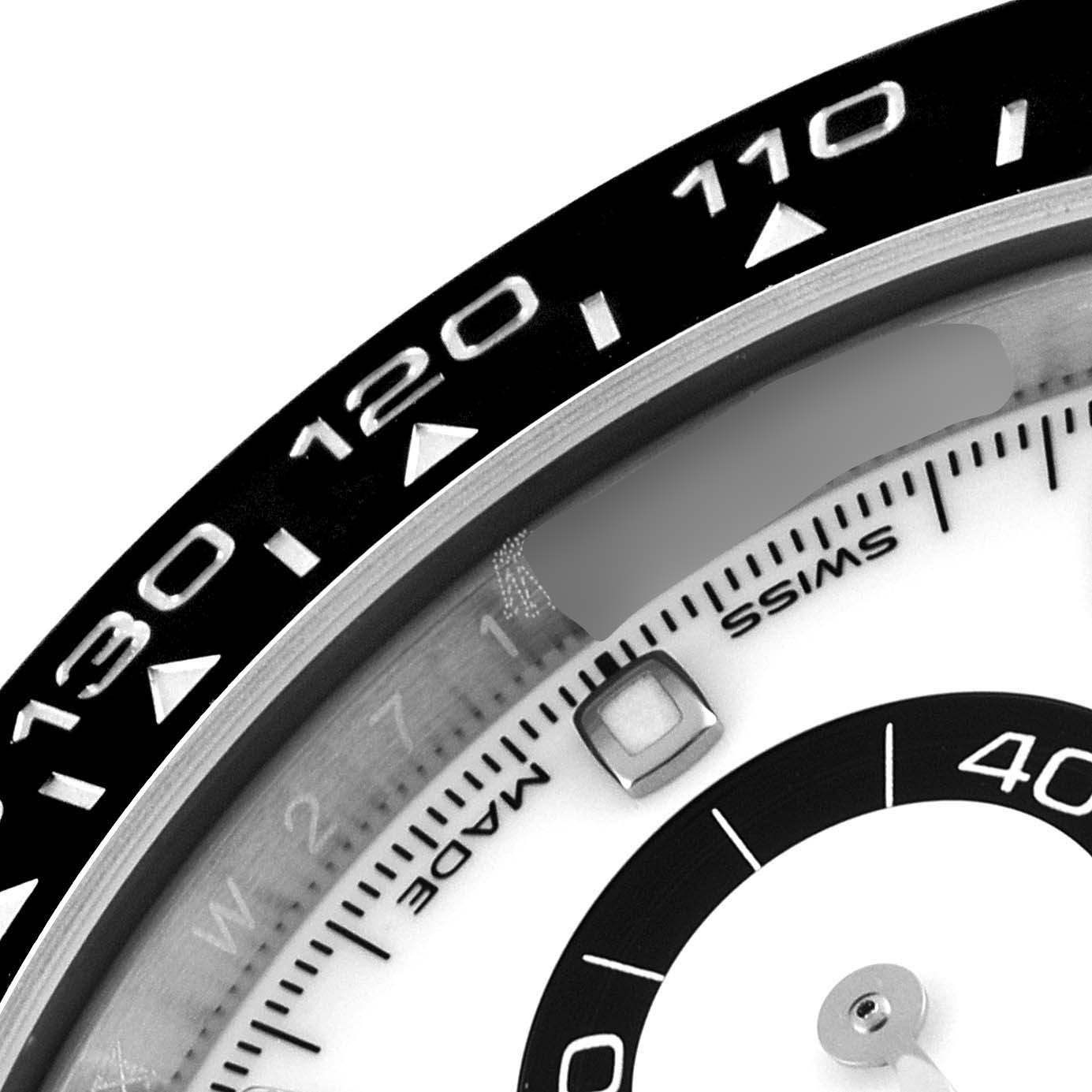 This close-up image shows a partial view of the bezel and dial of a Rolex Daytona 116500 Men's Stainless Steel White Dial 116500 Men's Stainless Steel White Dial watch, highlighting the tachymeter scale and chronograph sub-dial.