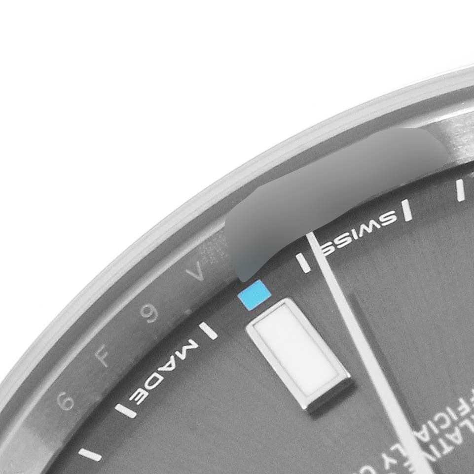 This image shows a close-up of the dial of a Rolex Oyster Perpetual 114300 Men's Stainless Steel Grey Dial 114300 Men's Stainless Steel Grey Dial watch, highlighting the Swiss made marking and part of the hour markers.