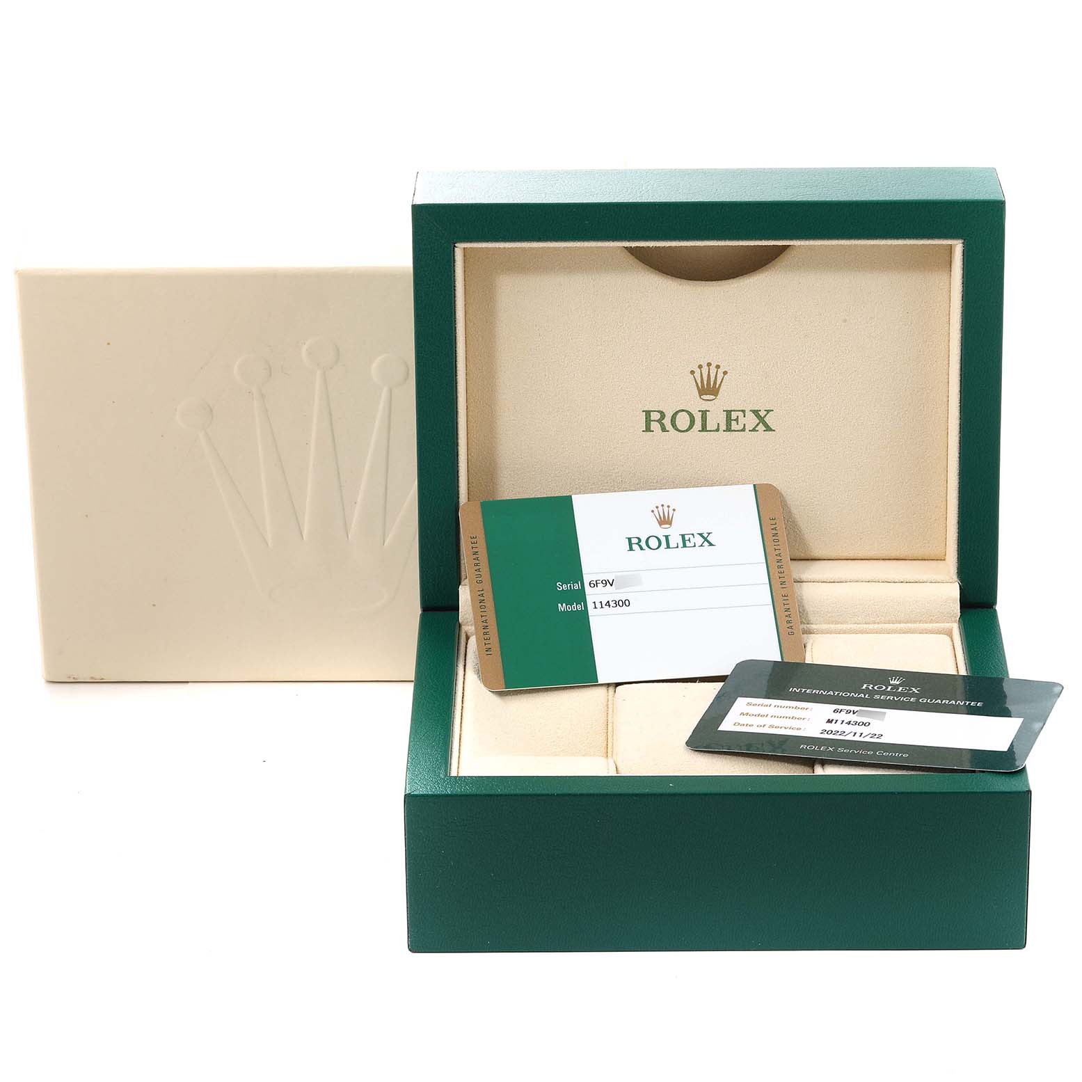 The image shows the packaging and certification cards for a Rolex Oyster Perpetual 114300 Men's Stainless Steel Grey Dial 114300 Men's Stainless Steel Grey Dial model, viewed from the front.