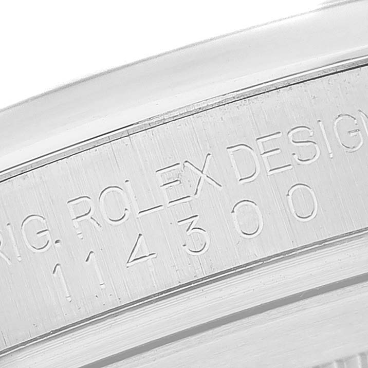 This close-up image shows the engraved side of the bezel on a Rolex Oyster Perpetual 114300 Men's Stainless Steel Grey Dial 114300 Men's Stainless Steel Grey Dial watch.
