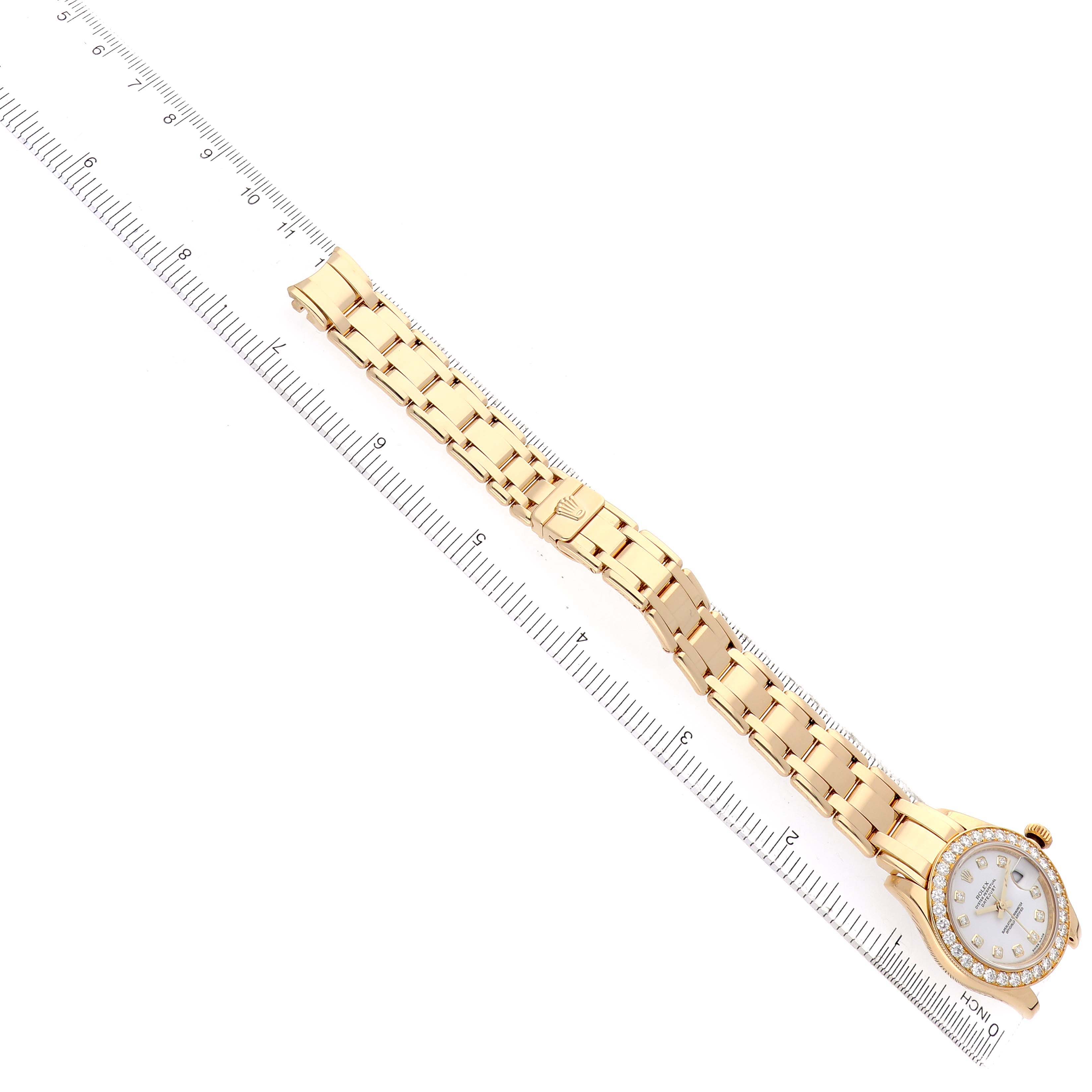 The Rolex Pearlmaster 80298 Women's Yellow Gold White Dial watch is shown from a top-down angle, displaying the full band and face next to a ruler for scale.