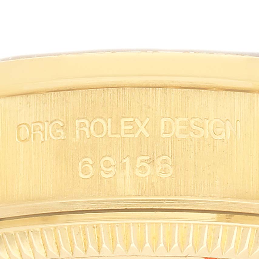 The image shows a close-up of the side of a Rolex President 69158 Women's Yellow Gold Champagne Dial watch, highlighting the engraved model number and design details.