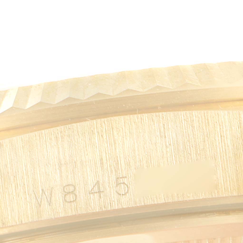 This close-up image shows the engraved part of the bezel and case of a Rolex President 18238 Men's Yellow Gold Champagne Dial 18238 Men's Yellow Gold Champagne Dial model watch.