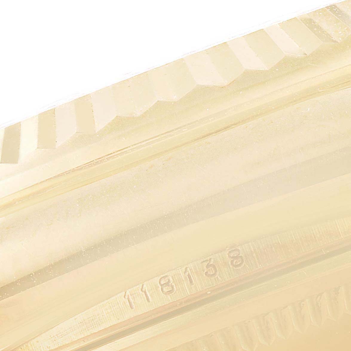 This image shows a close-up of the fluted bezel and part of the casing of a Rolex President 118139 Men's Yellow Gold Brown Dial 118139 Men's Yellow Gold Brown Dial model watch.