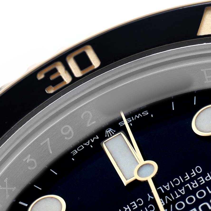 The image shows a close-up of the bezel and dial of the Rolex Submariner 126613 Men's Steel and Gold (two tone) Black Dial, focusing on the minute markings and hands.