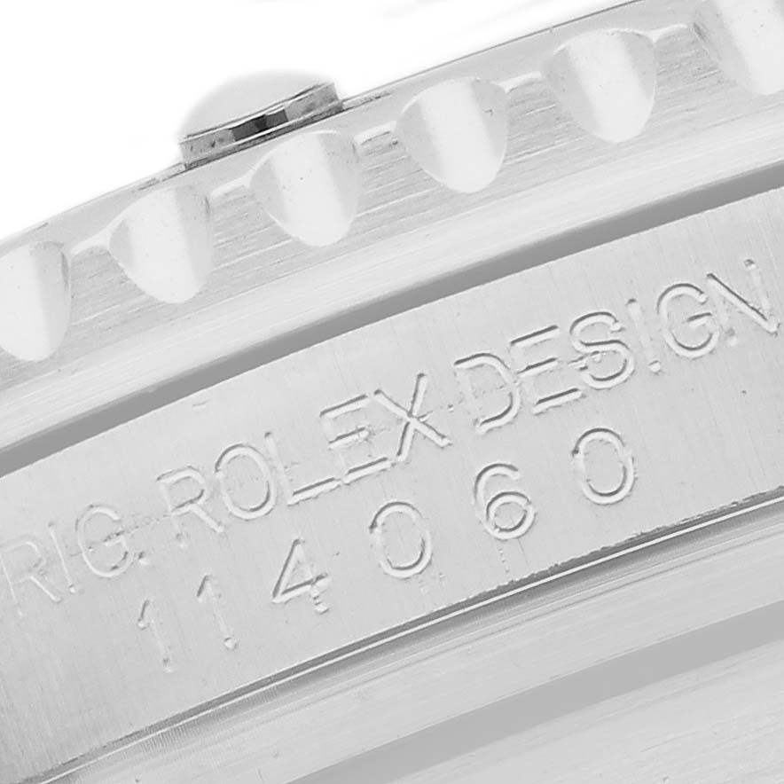 The image shows a close-up of the side of the bezel and case engraving on a Rolex Submariner 114060 Men's Stainless Steel Black Dial watch.