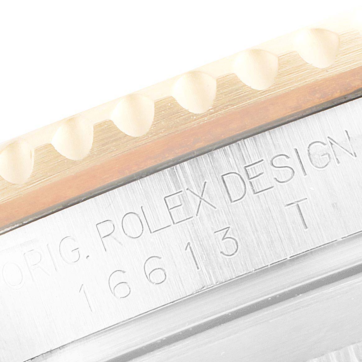 The image shows a close-up of the Rolex Submariner 16613 Men's Steel and Gold (two tone) Blue Dial 16613 Men's Steel and Gold (two tone) Blue Dial's bezel and the engraved model number "16613 T".