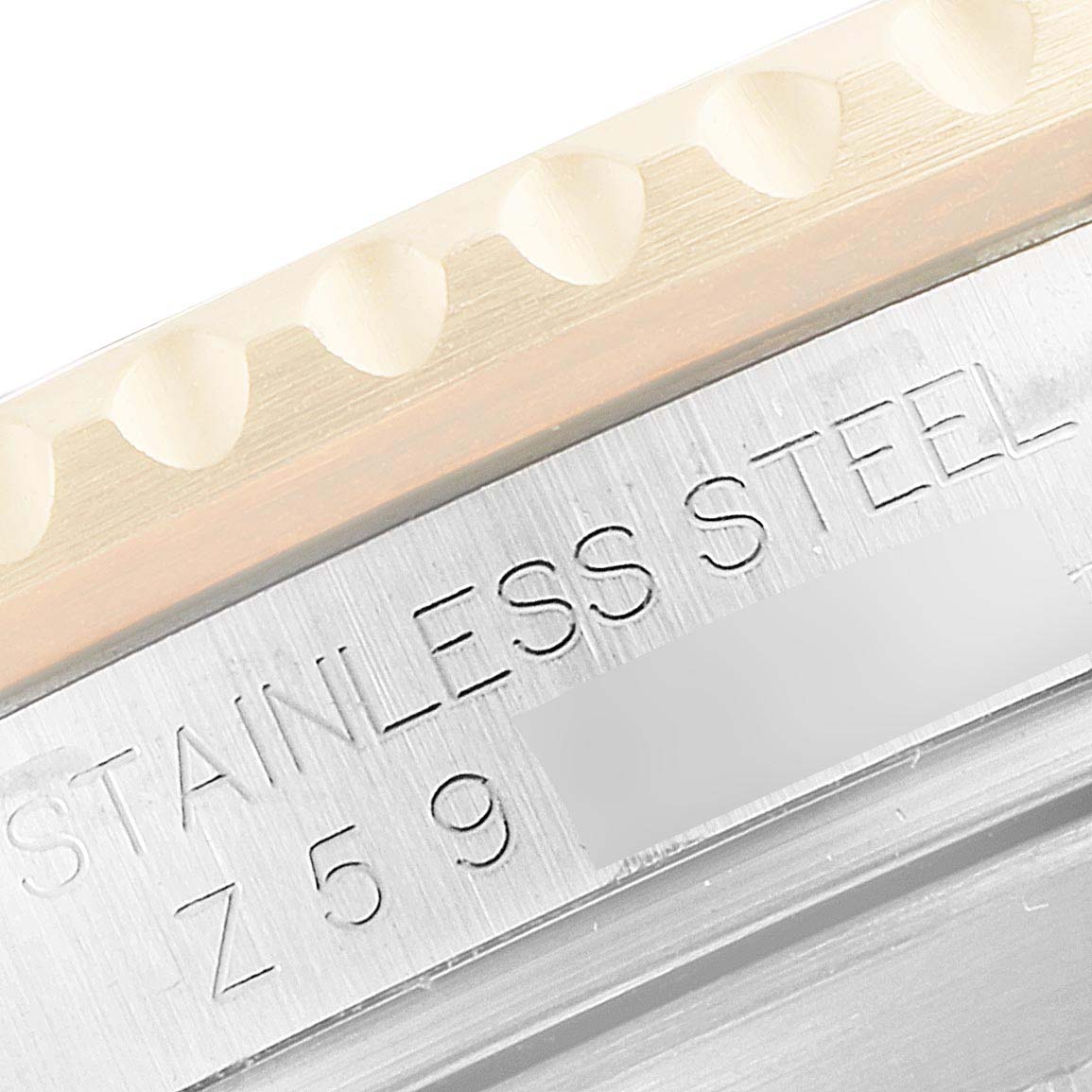 The image shows a close-up of the edge and part of the bezel and case, focusing on the engraved "STAINLESS STEEL" text of the Rolex Submariner 16613 Men's Steel and Gold (two tone) Blue Dial 16613 Men's Steel and Gold (two tone) Blue Dial.