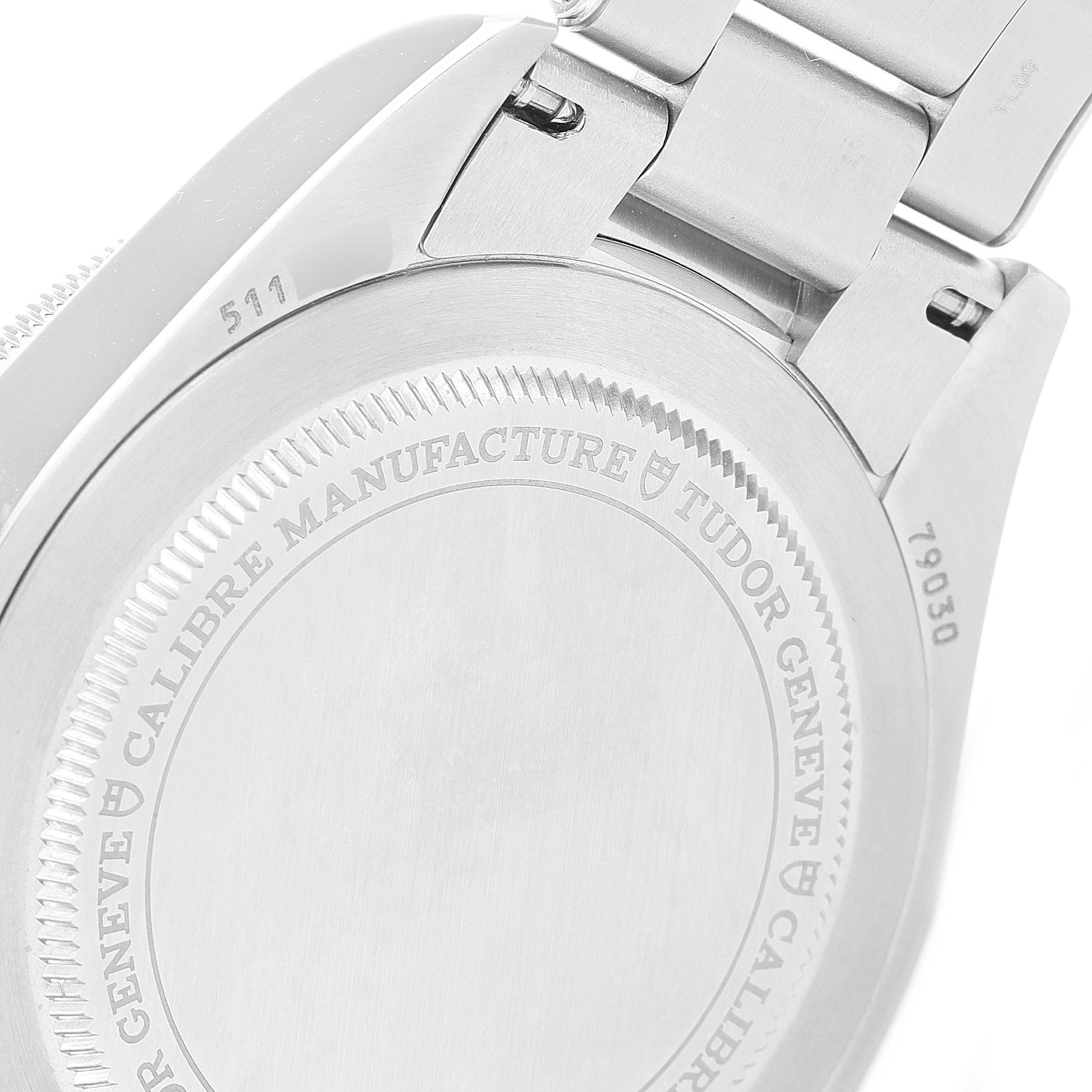 The image shows the backside and a partial bracelet of a Tudor Heritage Black Bay 79030B Men's Stainless Steel Blue Dial 79030B Men's Stainless Steel Blue Dial watch, highlighting its case back and engravings.