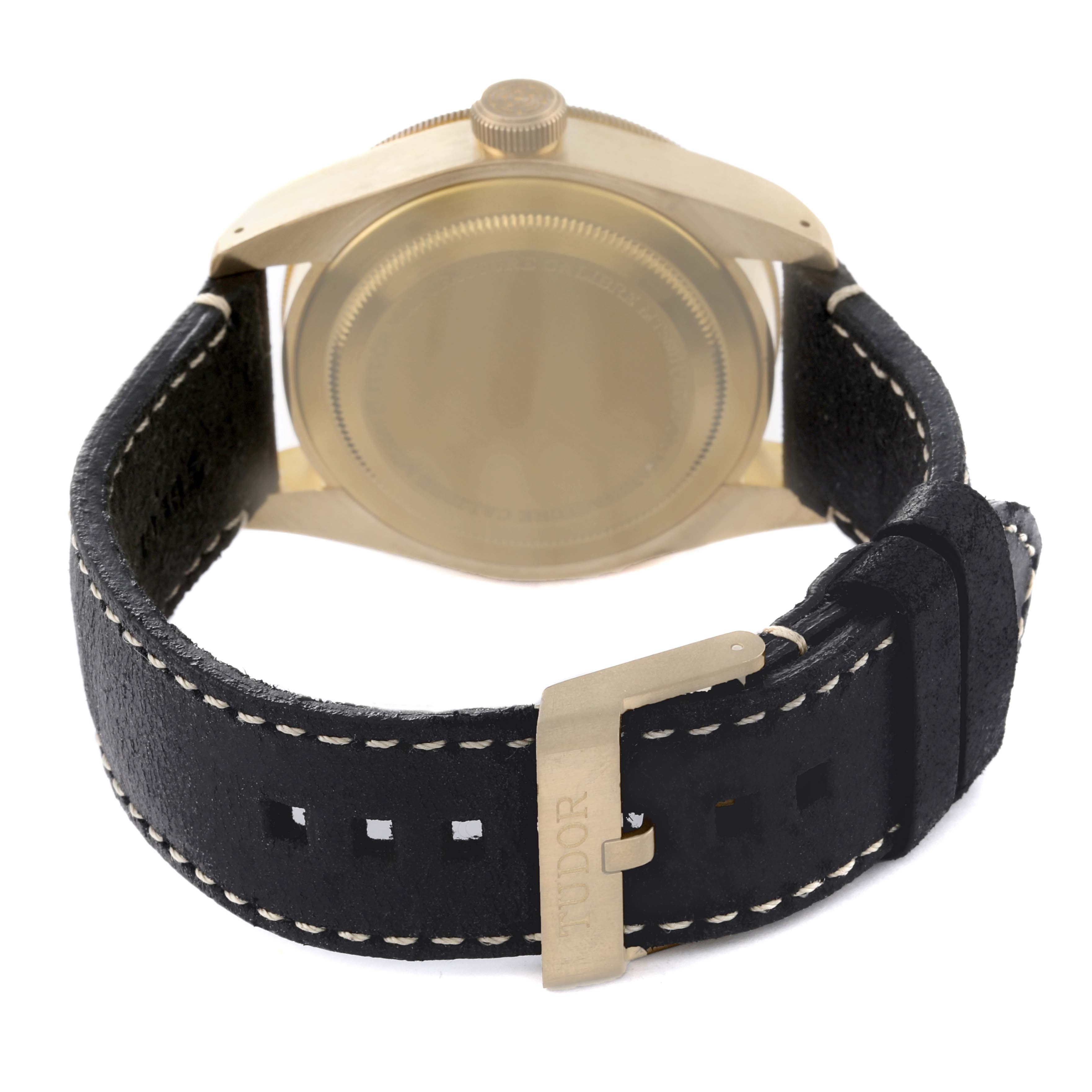 The image shows the rear view of the Tudor Heritage Black Bay 79250BA Men's Bronze Black Dial 79250BA Men's Bronze Black Dial watch with focus on the back case and black leather strap with stitching.