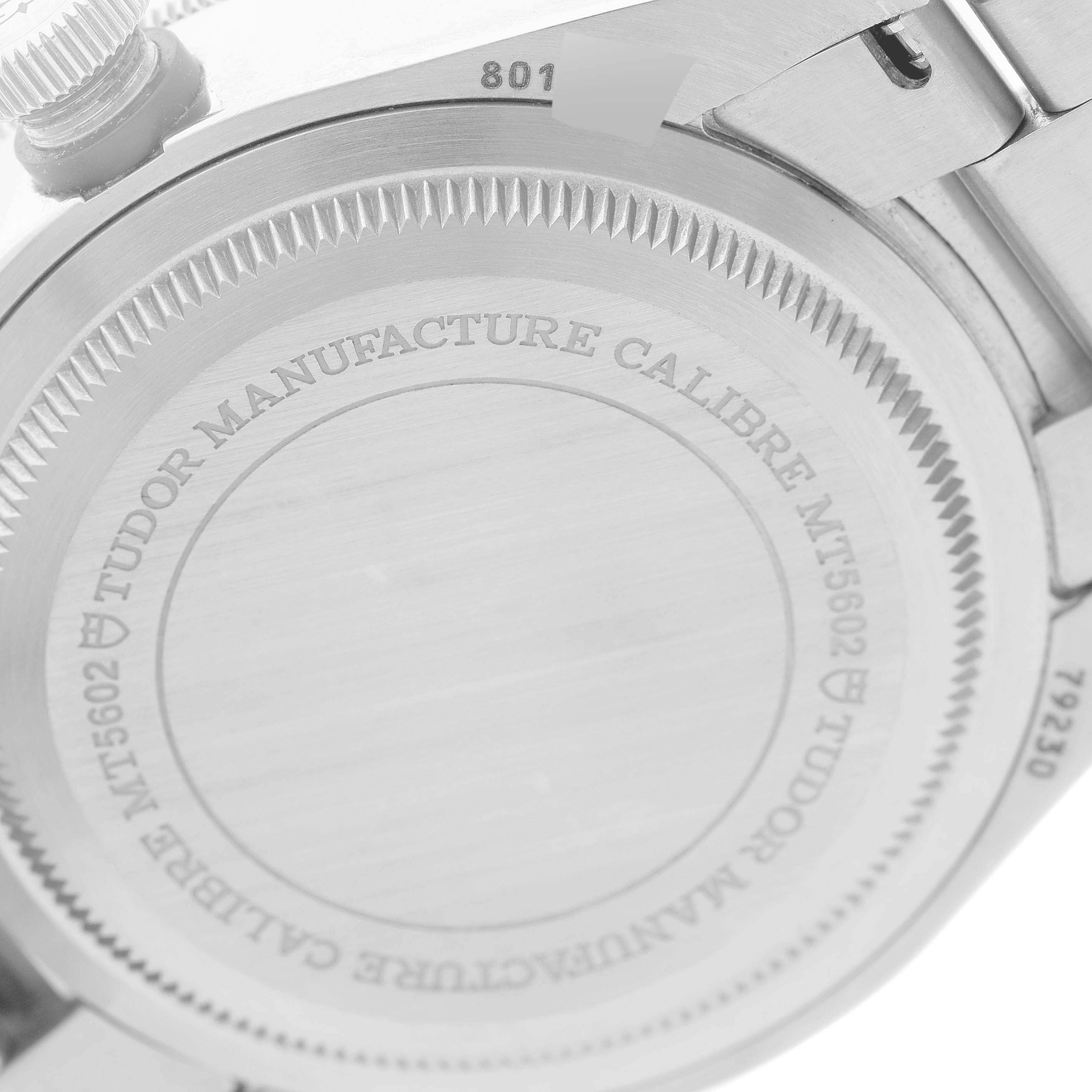 The image shows a close-up of the case back of a Tudor Heritage Black Bay 79230N Men
s Stainless Steel Black Dial 79230N Men
s Stainless Steel Black Dial watch, highlighting the engraved text and bezel detailing.