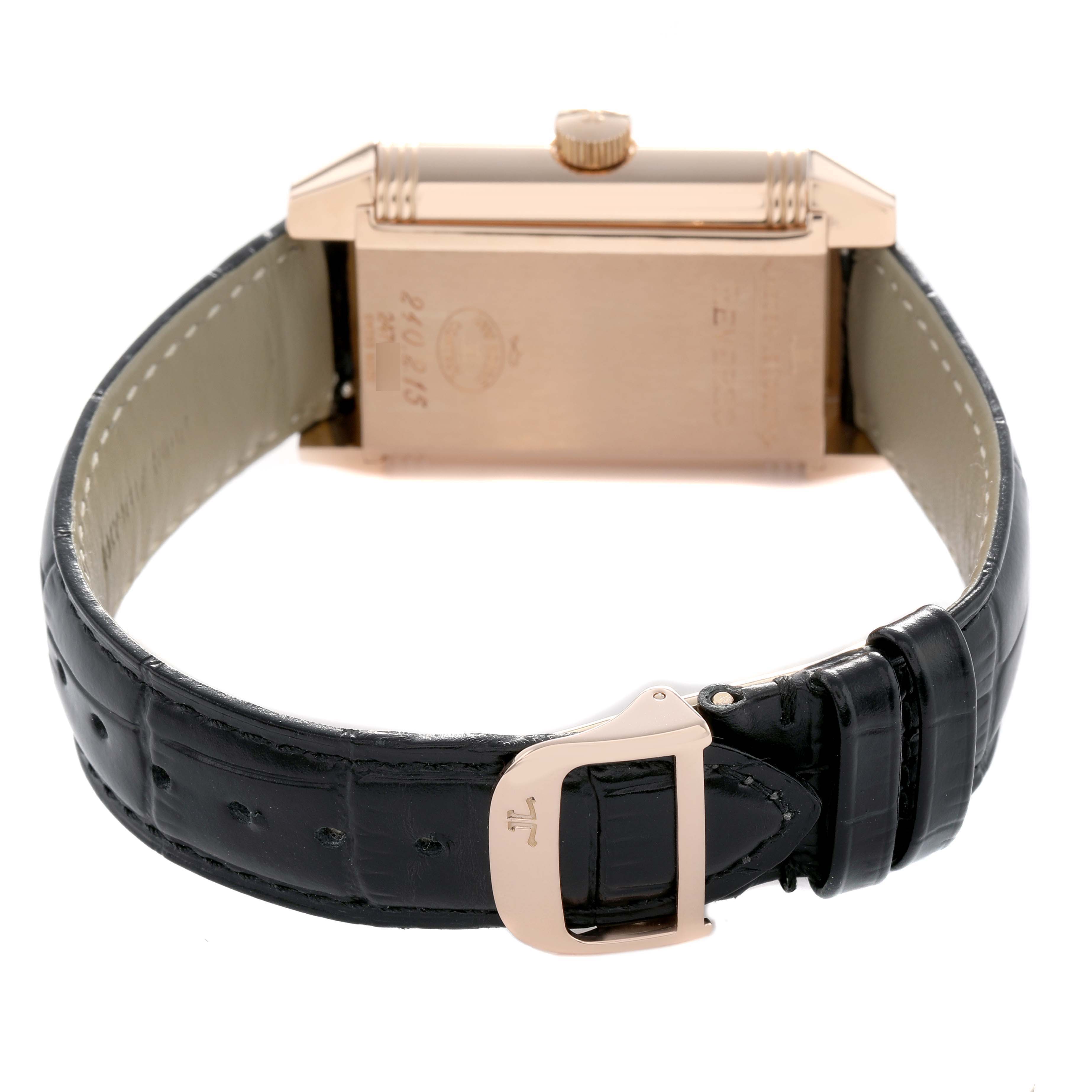 The Jaeger-LeCoultre Reverso is shown from the rear, highlighting the case back, crown, and leather strap with clasp.