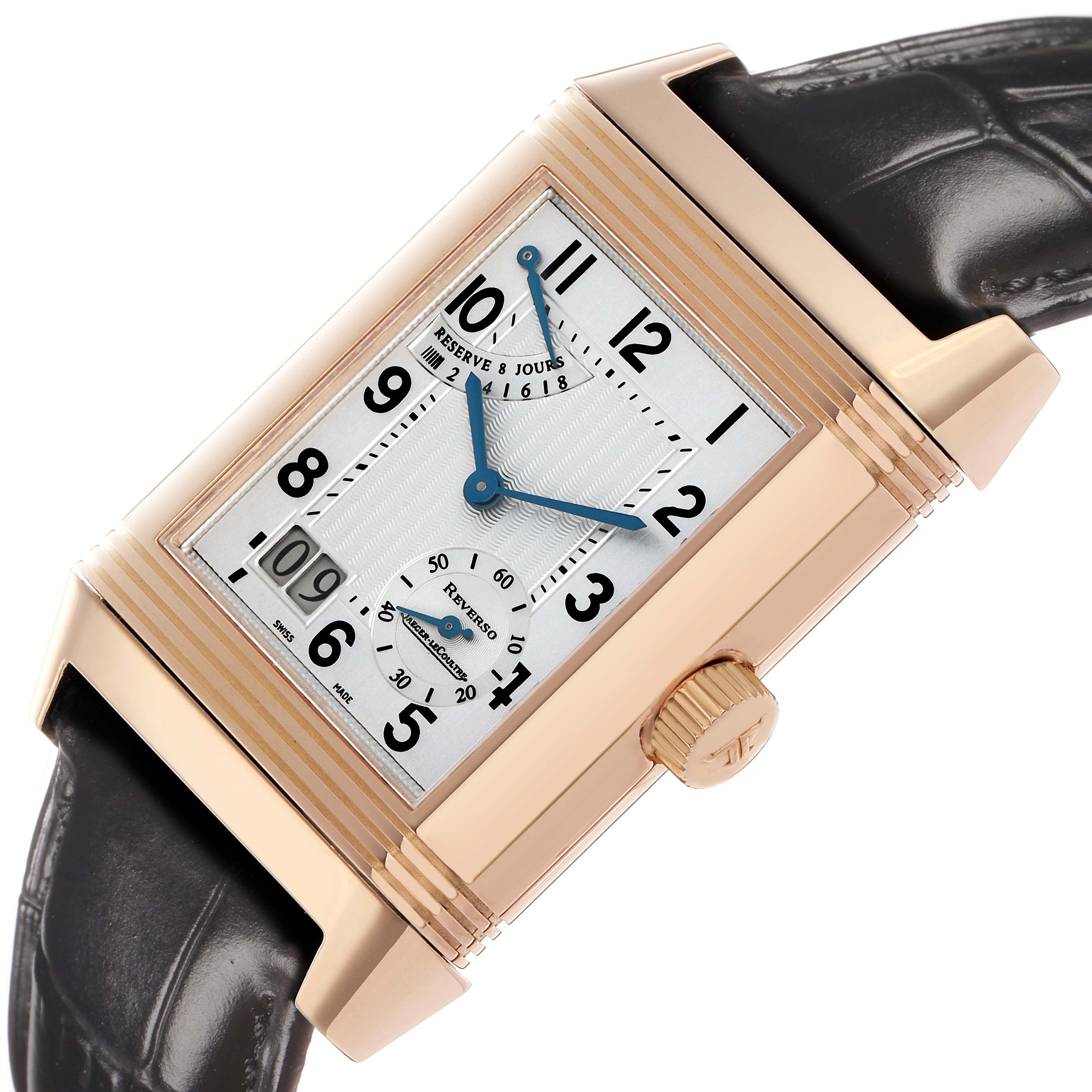 The Jaeger-LeCoultre Reverso watch is shown at a slight angle, displaying its rectangular face, crown, and black leather strap.