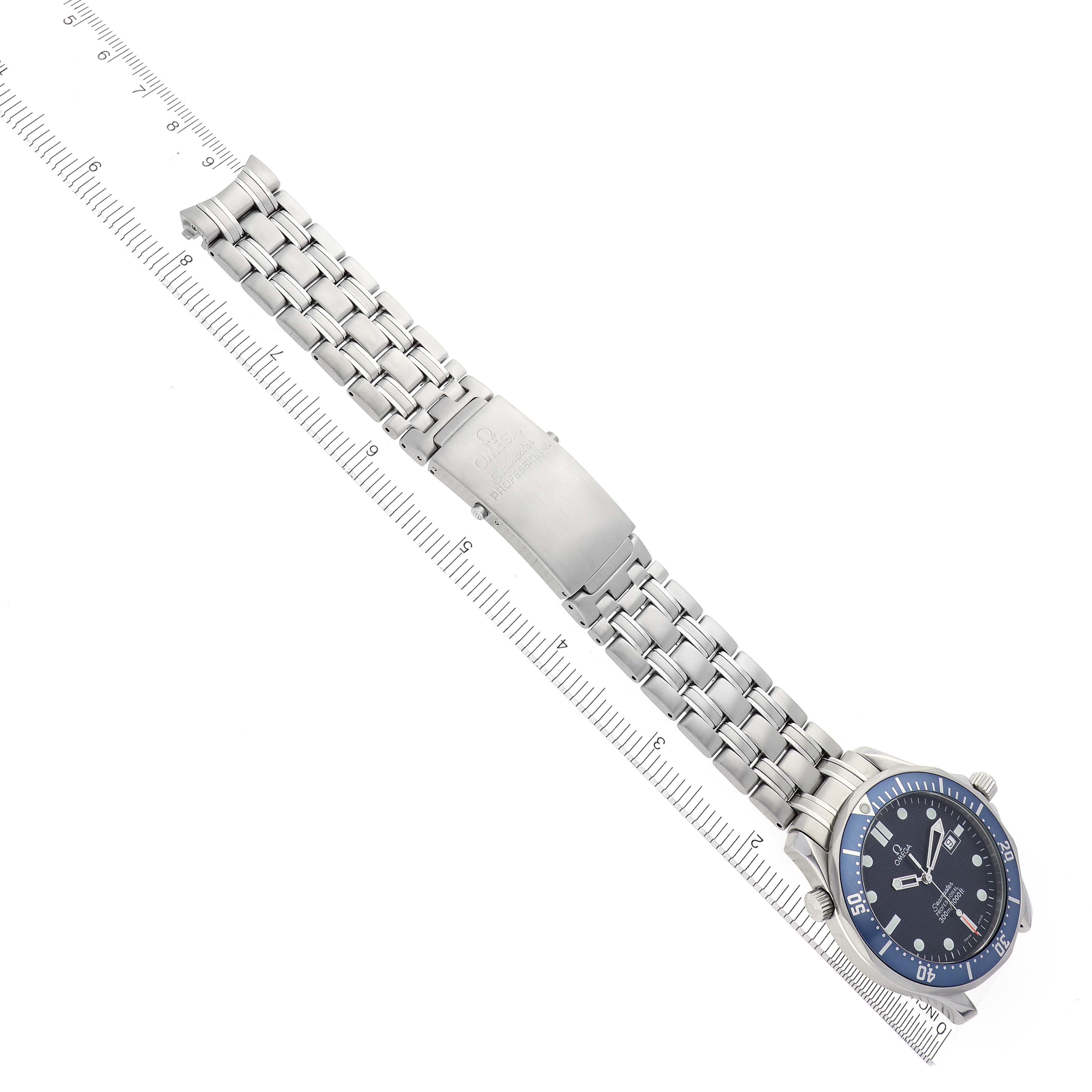 The Omega Seamaster 2541.80.00 Men
s Stainless Steel Blue Dial 2541.80.00 Men
s Stainless Steel Blue Dial watch is shown at an angle highlighting the face and full metal bracelet alongside a ruler.