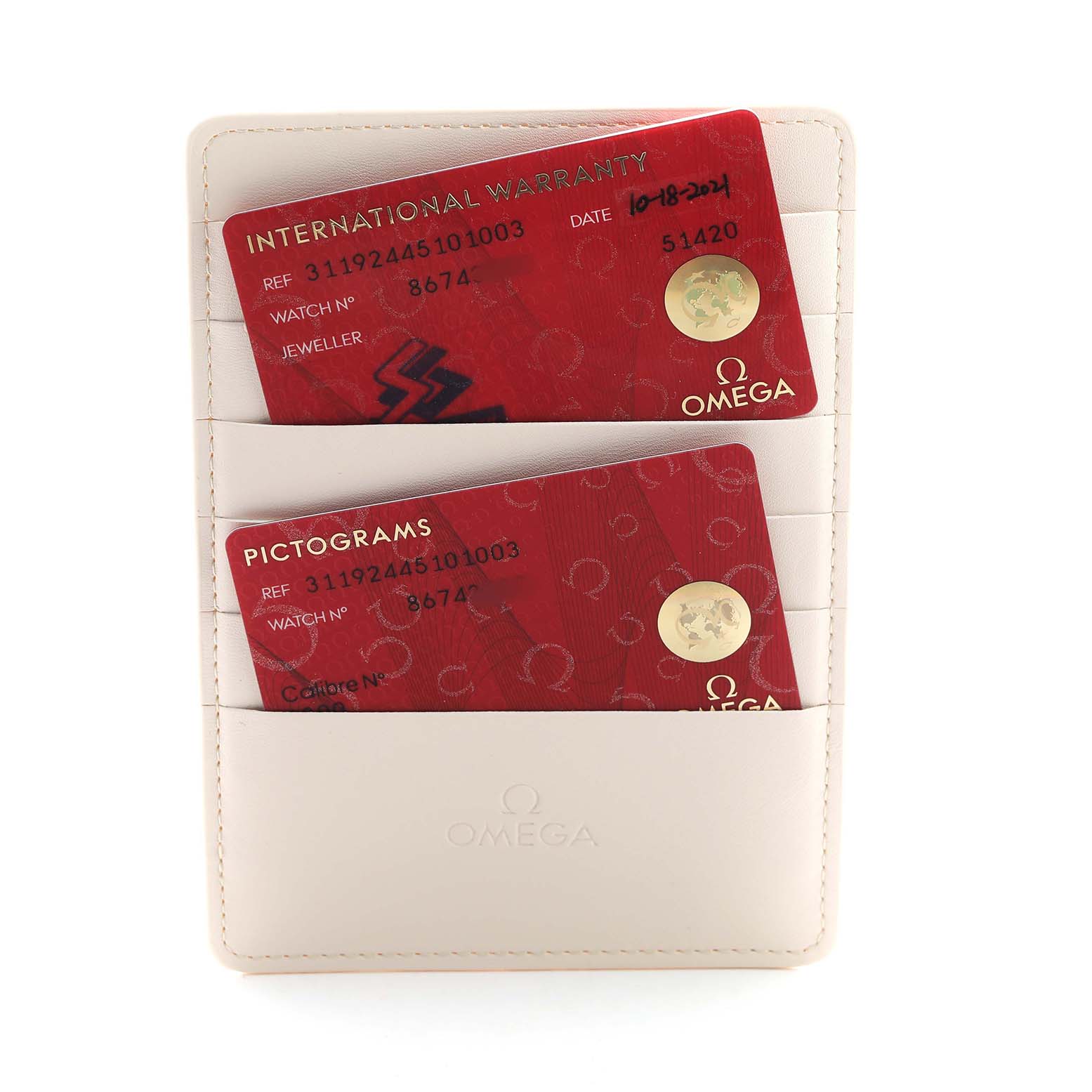 The image shows warranty and pictograms cards for an Omega Speedmaster 311.92.44.51.01.003 Men's Ceramic Black Dial, placed in a leather holder.