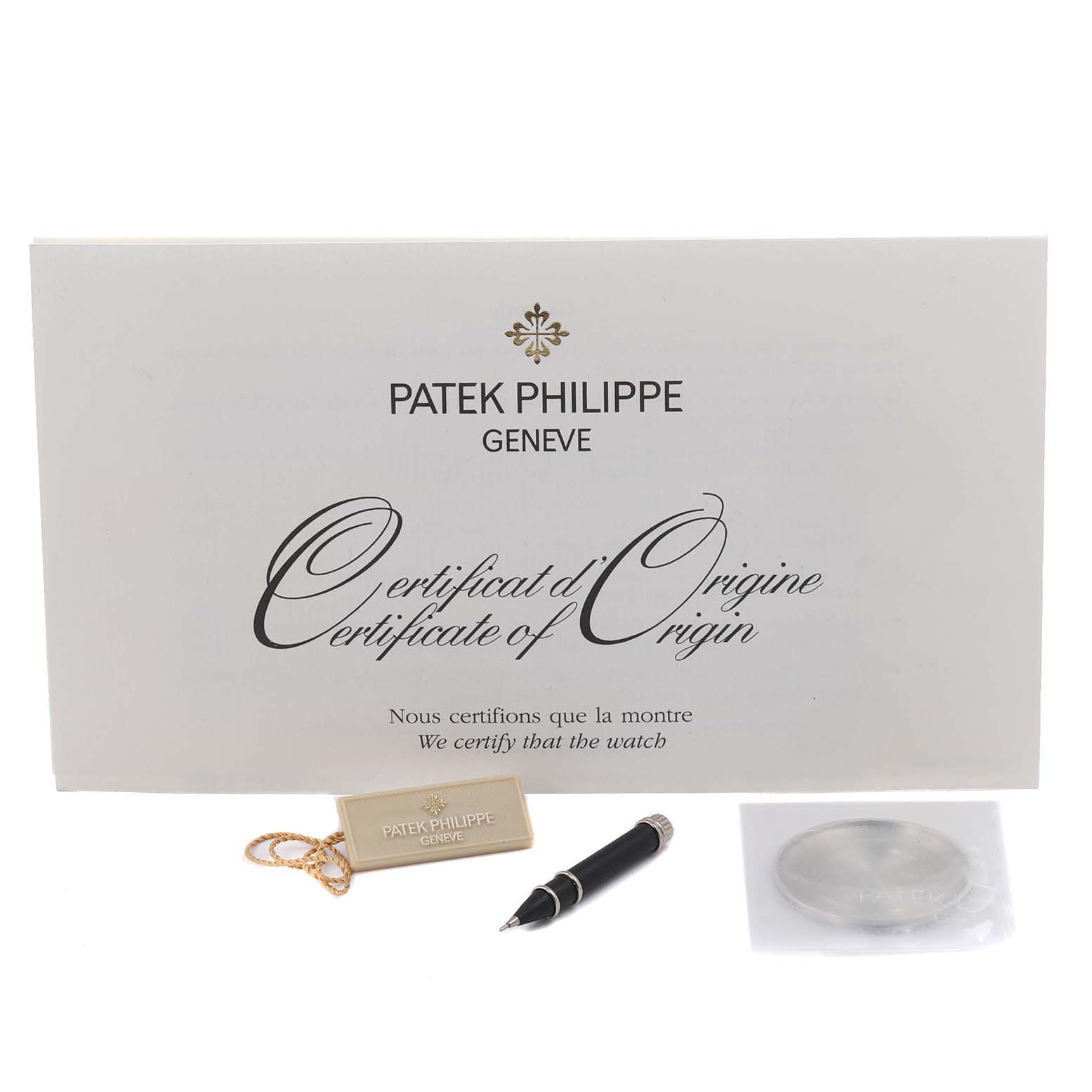 The image shows a Patek Philippe Complications 5496P-014 Men's Platinum Brown Dial 5496P-014 Men's Platinum Brown Dial model certificate, a pen, a tag, and a sealed accessory in a straight-on view.