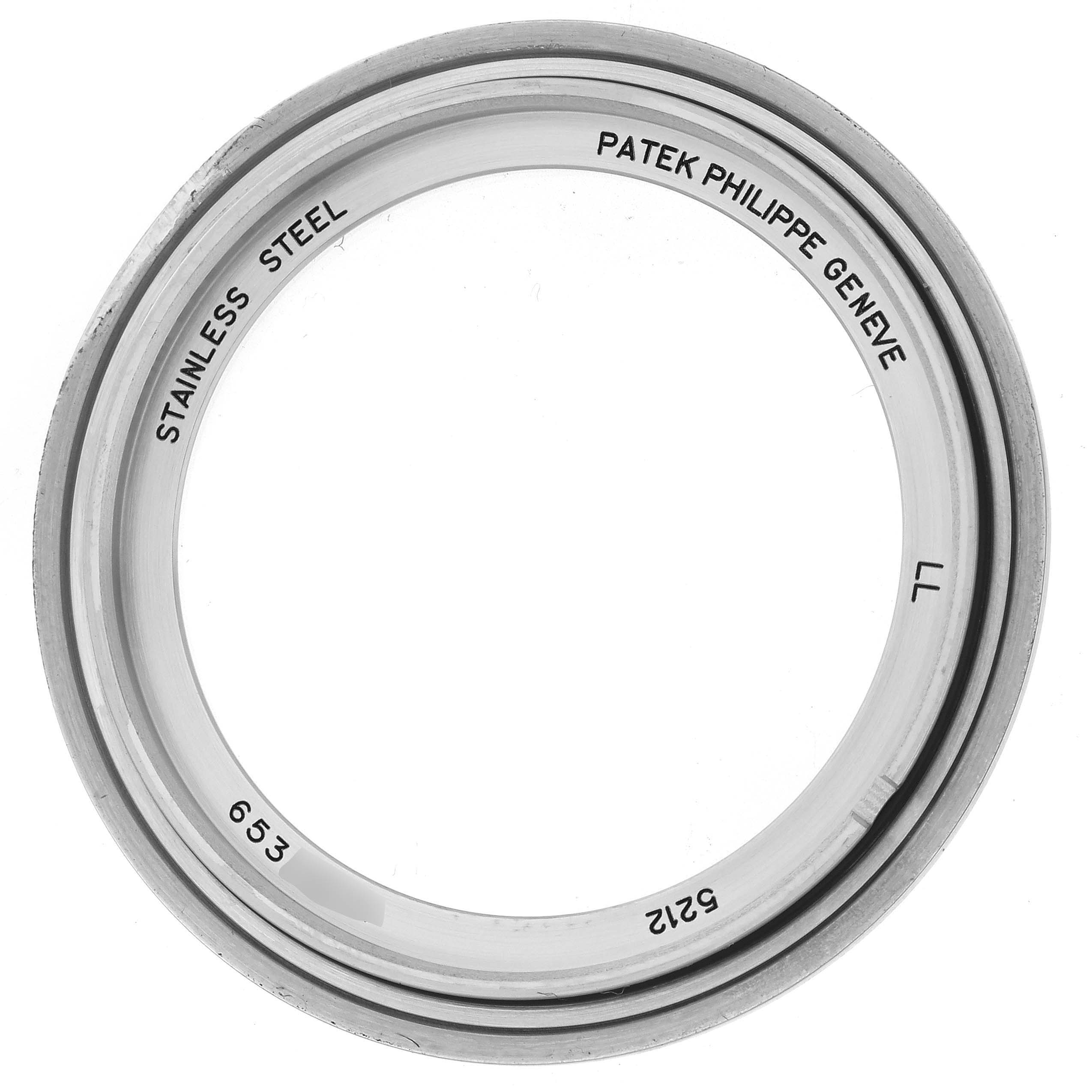 This is a bezel of a Patek Philippe Complications 5212A-001 Men's Stainless Steel Silver Dial 5212A-001 Men's Stainless Steel Silver Dial watch, viewed head-on, showing stainless steel markings and serial numbers.