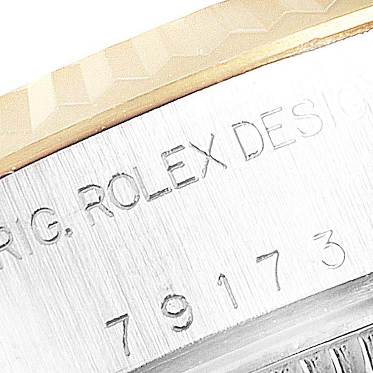The image shows an angled close-up of the bezel and engraved serial number on a Rolex Datejust 79173 Women's Steel and Gold (two tone) White Dial 79173 Women's Steel and Gold (two tone) White Dial watch.