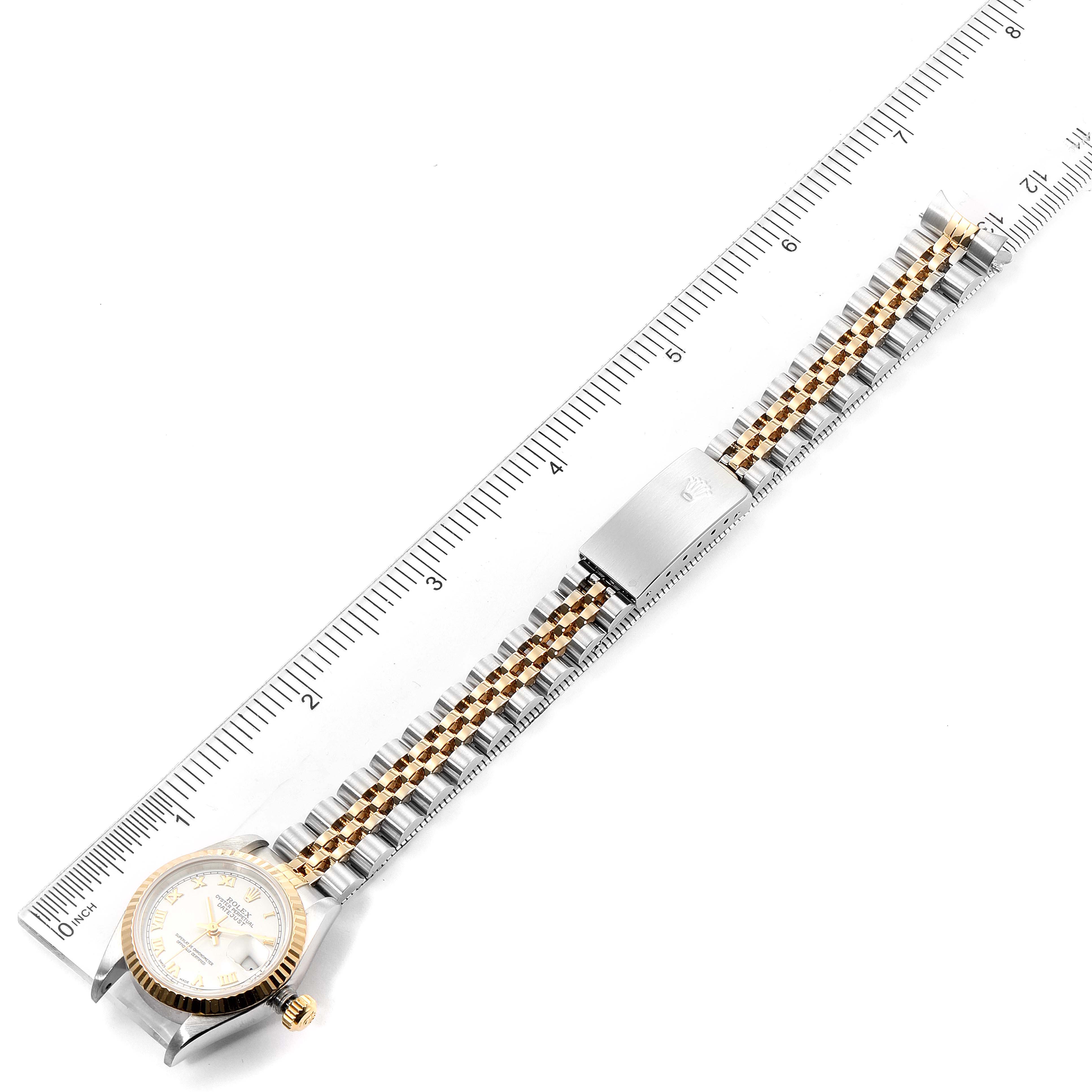 The image shows an overhead view of a Rolex Datejust 79173 Women's Steel and Gold (two tone) White Dial 79173 Women's Steel and Gold (two tone) White Dial watch, displaying the full bracelet and the clasp, against a ruler for measurement.