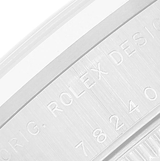 This close-up image shows the side of a Rolex Mid-Size 78240 Women
s Stainless Steel White Dial 78240 Women
s Stainless Steel White Dial watch case with engraved text.