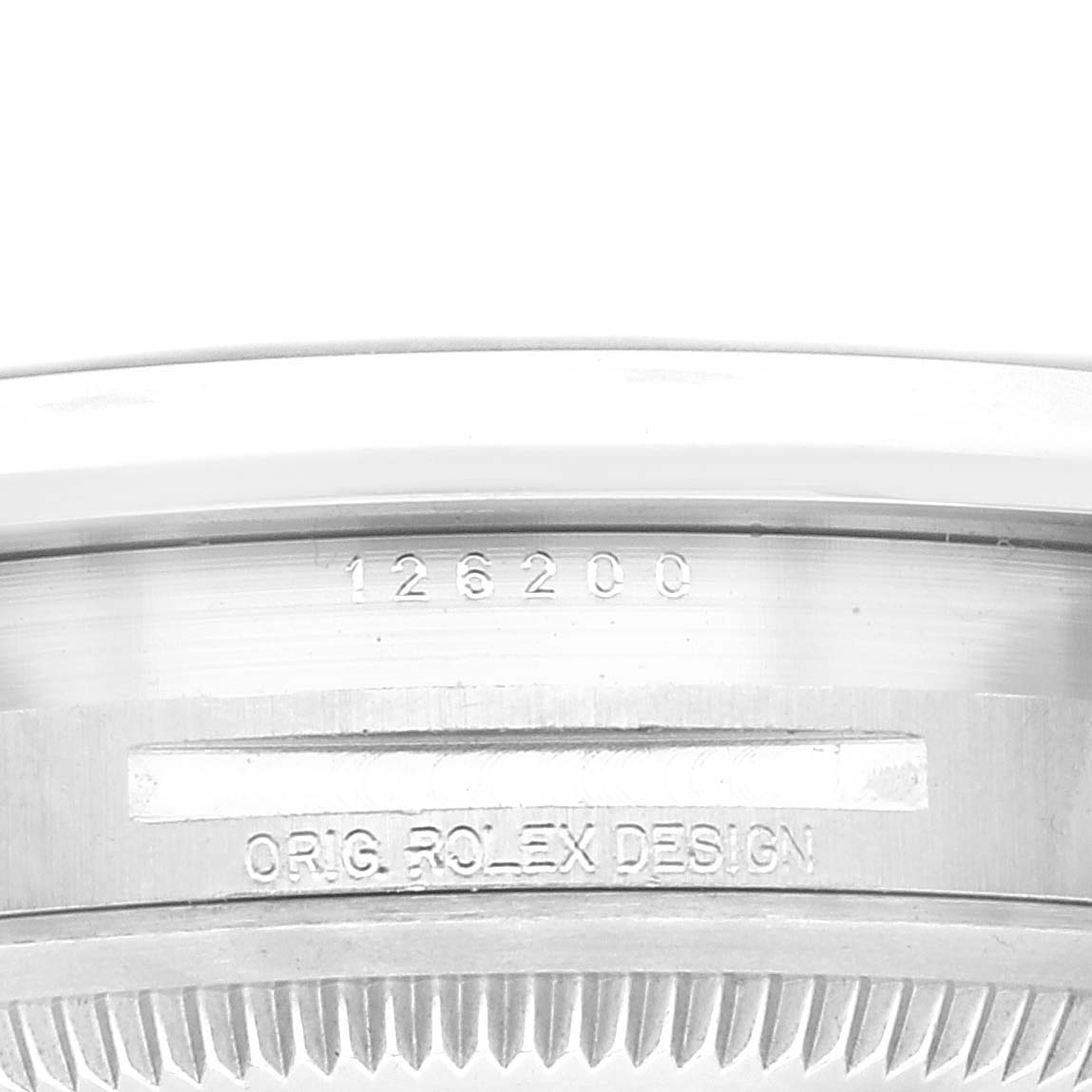 The image shows the side of the bezel and case of a Rolex Datejust 126200 Men's Stainless Steel Grey Dial 126200 Men's Stainless Steel Grey Dial watch, featuring engravings and part of the fluted bezel.