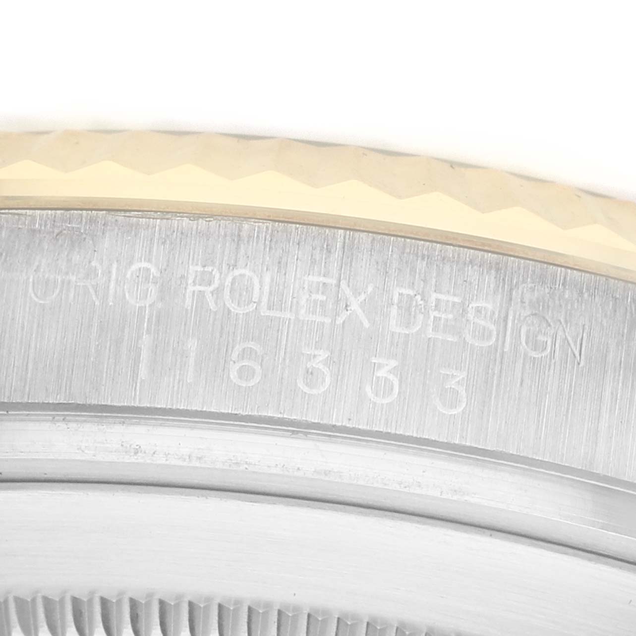 The image shows a close-up of the engraved edge and part of the bezel of a Rolex Datejust 41 116333 Men's Steel and Gold (two tone) Silver Dial watch.