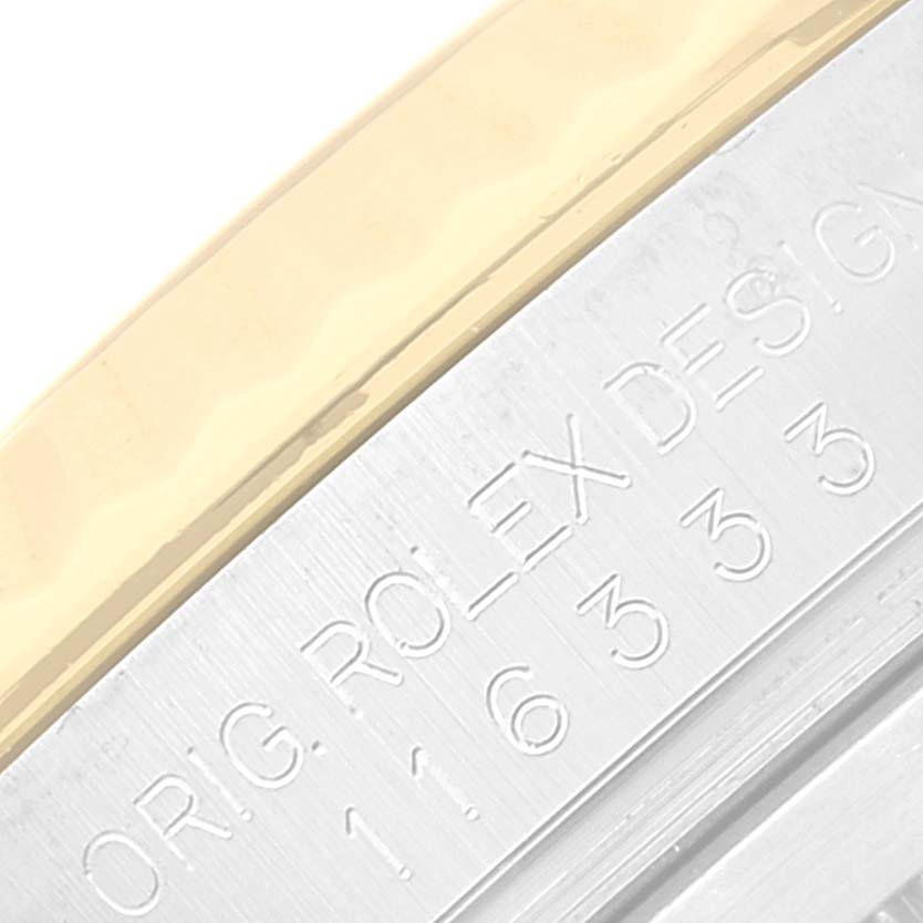 This image shows a close-up of the bezel and part of the case of a Rolex Datejust 41 116333 Men's Steel and Gold (two tone) Champagne Dial 116333 Men's Steel and Gold (two tone) Champagne Dial, displaying the engraving details.