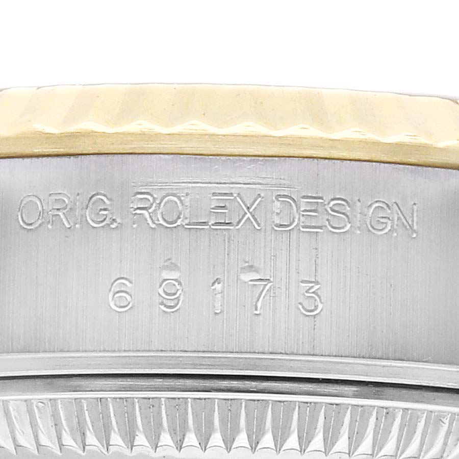 The image shows a close-up of the side of a Rolex Datejust 69173 Women's Steel and Gold (two tone) Black Dial, focusing on the engraved bezel with the "ORIG. ROLEX DESIGN" text and model number.