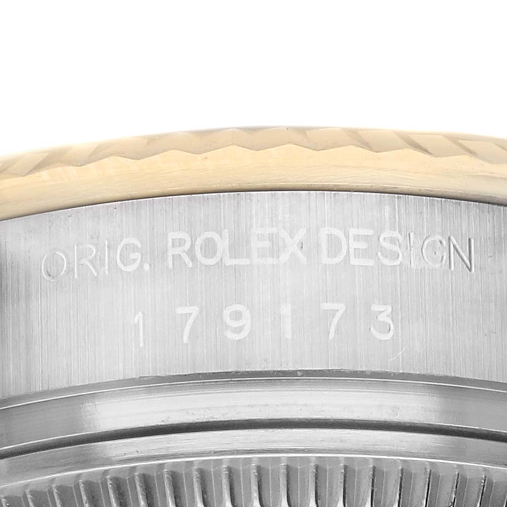 The image shows the side view of a Rolex Datejust 179173 Women's Steel and Gold (two tone) Black Dial watch, highlighting the engraved model number and part of the fluted bezel.