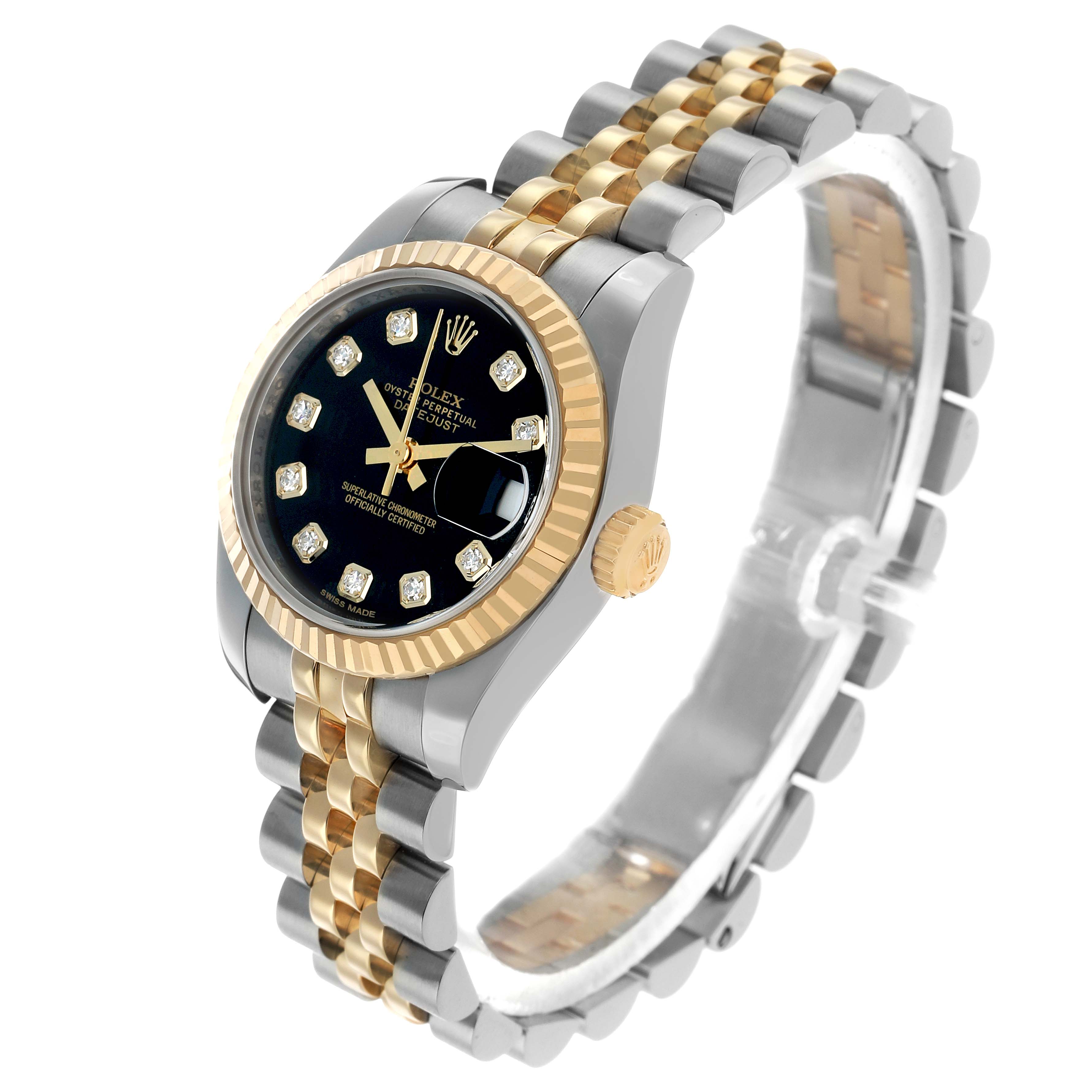 The Rolex Datejust 179173 Women's Steel and Gold (two tone) Black Dial watch is shown at a three-quarter angle, highlighting the black dial, gold bezel, and two-tone bracelet.