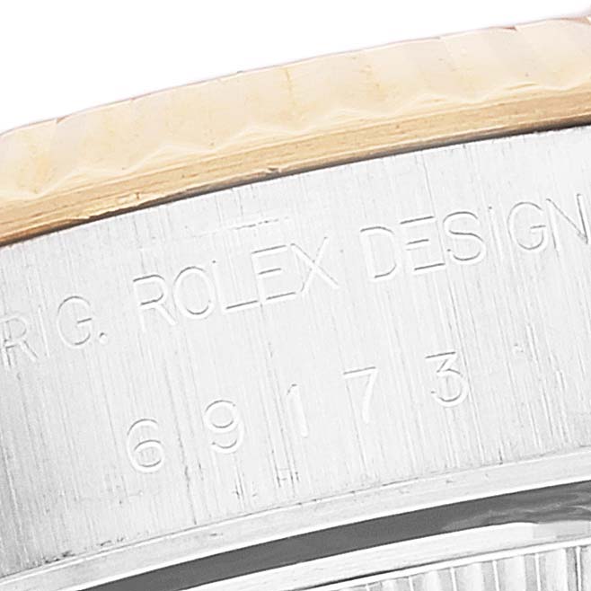 This close-up image shows the engraved serial number and part of the bezel of a Rolex Datejust 69173 Women's Steel and Gold (two tone) Champagne Dial 69173 Women's Steel and Gold (two tone) Champagne Dial watch.