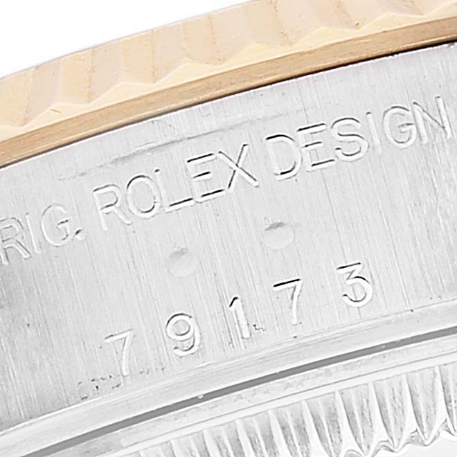 This image shows a close-up of the side of the bezel and the engraved case of the Rolex Datejust 79173 Women's Steel and Gold (two tone) Champagne Dial 79173 Women's Steel and Gold (two tone) Champagne Dial model.