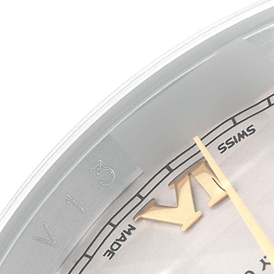 This close-up angle of a Rolex Datejust 116233 Men's Steel and Gold (two tone) Beige Dial 116233 Men's Steel and Gold (two tone) Beige Dial watch shows part of the dial with "Swiss Made" writing and the edge of the bezel.