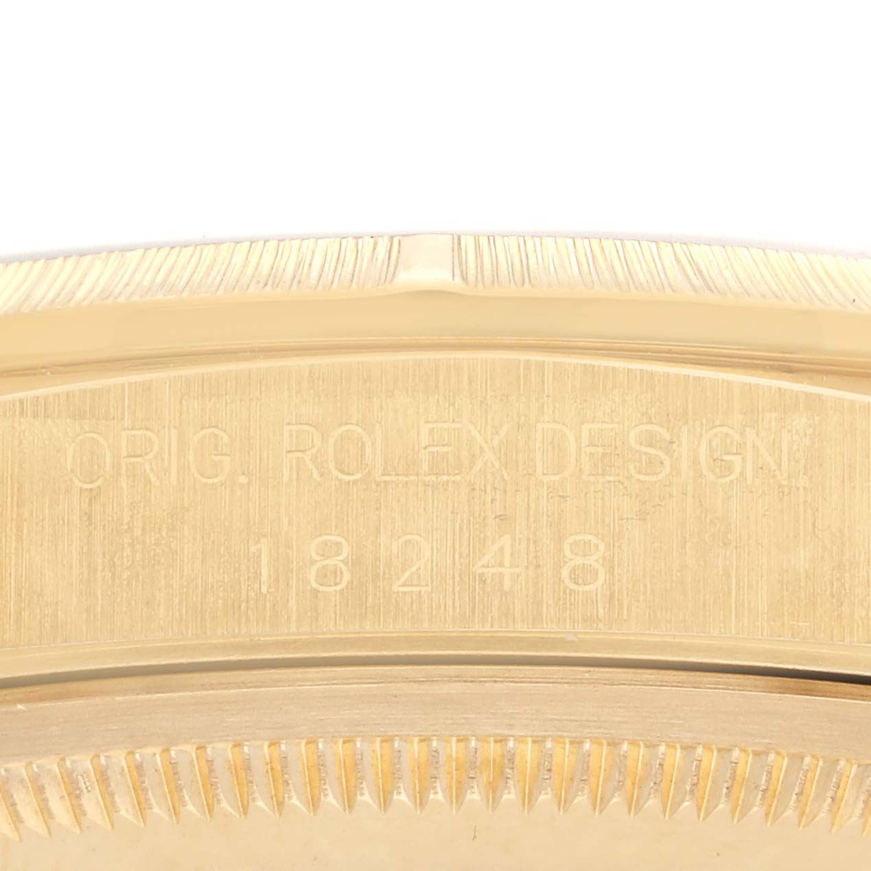 The image shows a close-up of the case side of a Rolex President 18248 Men's Yellow Gold White Dial 18248 Men's Yellow Gold White Dial model, highlighting the engravings and part of the bezel.