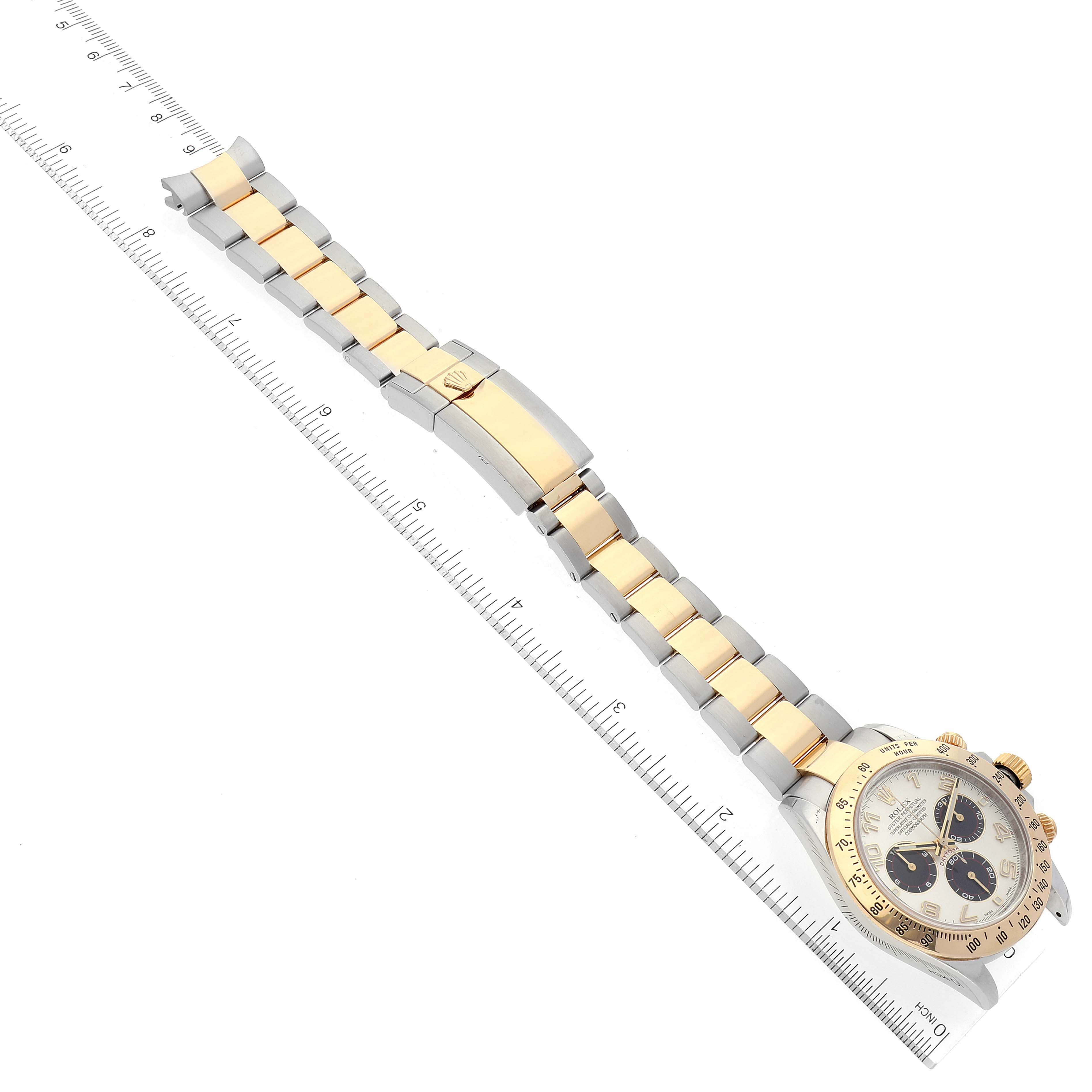 The image shows a Rolex Daytona 116523 Men's Steel and Gold (two tone) Silver Dial 116523 Men's Steel and Gold (two tone) Silver Dial watch laid flat, capturing the bracelet, clasp, and face, next to a ruler for size reference.