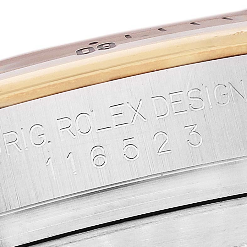 The image shows a close-up of the engraved model number and design markings on the side of a Rolex Daytona 116523 Men's Steel and Gold (two tone) Silver Dial 116523 Men's Steel and Gold (two tone) Silver Dial watch case.