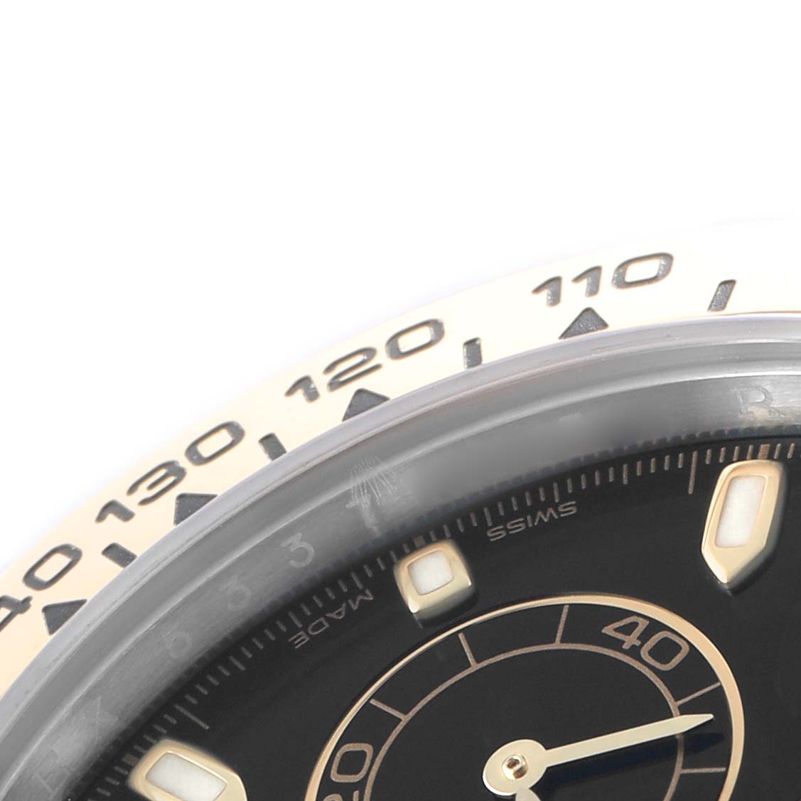 The image shows a close-up of the Rolex Daytona 116503 Men's Steel and Gold (two tone) Black Dial watch, focusing on the bezel and part of the dial with hour markers.