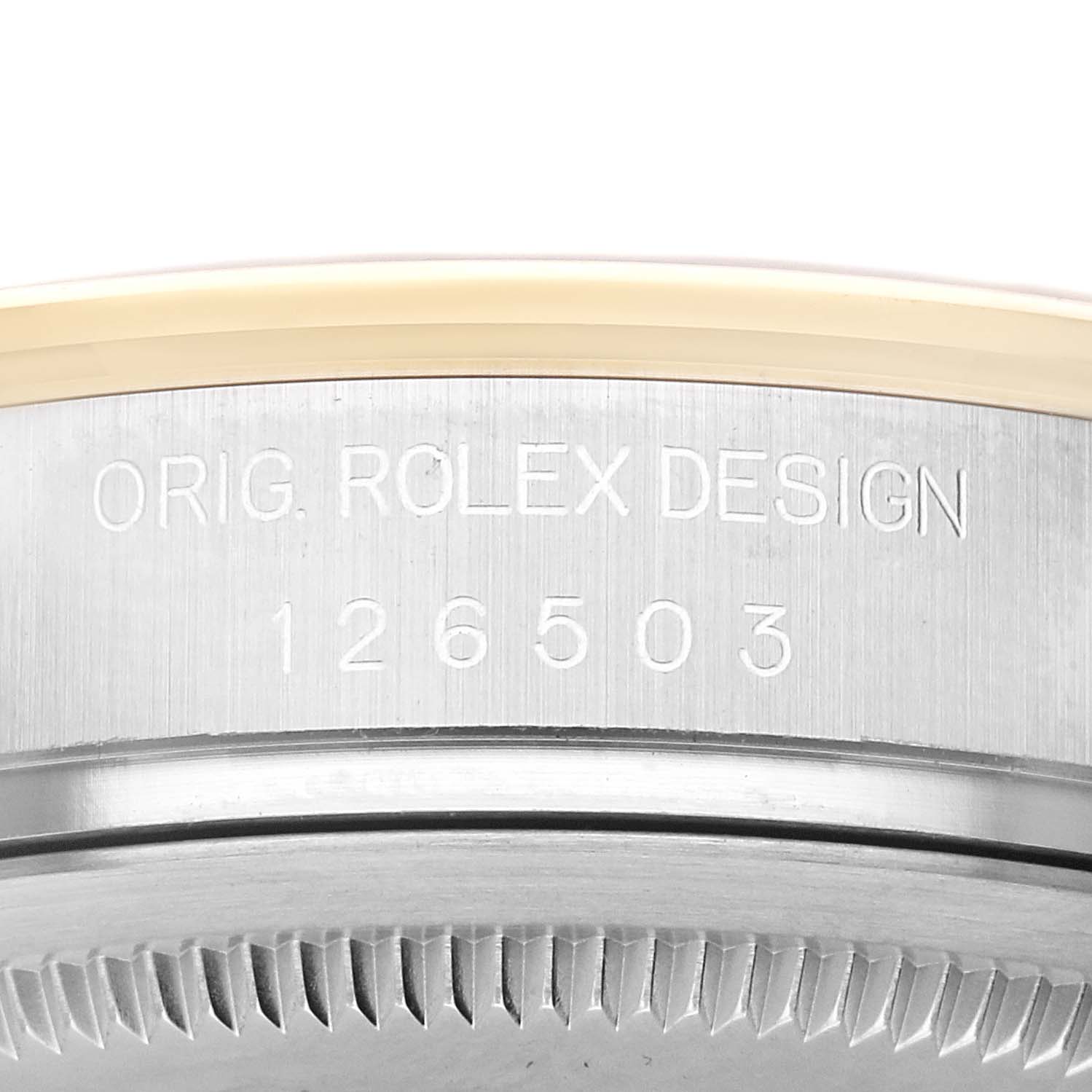 The image shows a close-up of the engraved serial number and Rolex branding on the side of a Daytona model by Rolex.