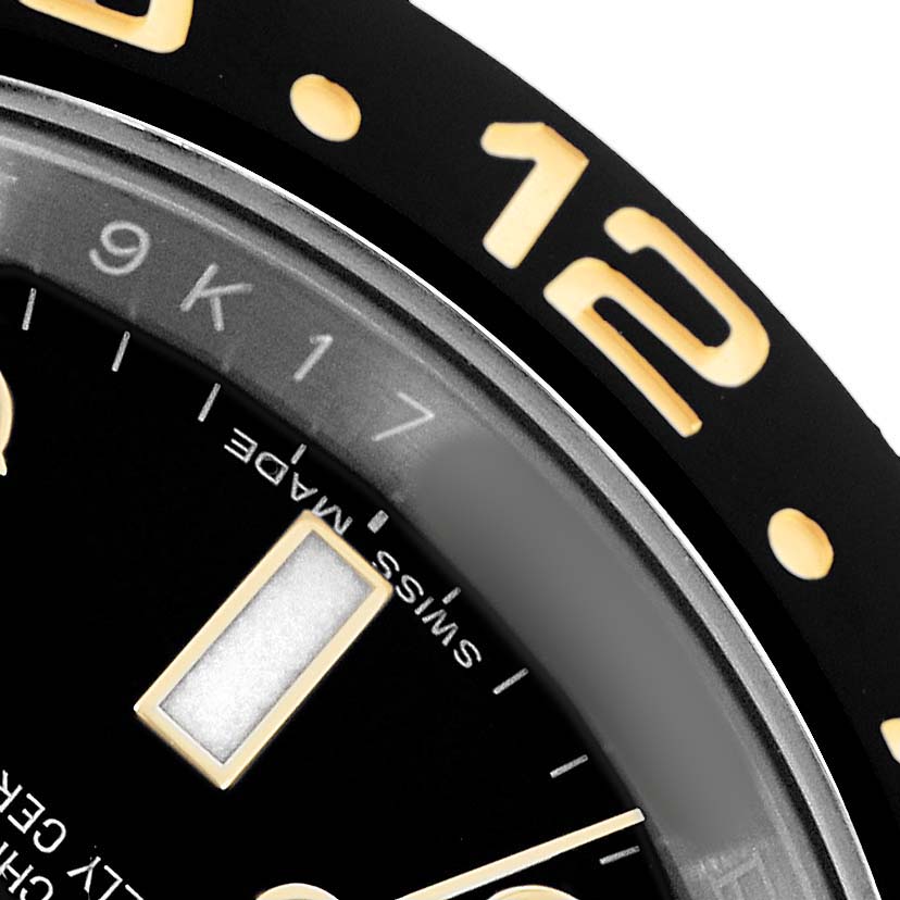 The image shows a close-up of the Rolex GMT-Master 116713 Men's Steel and Gold (two tone) Black Dial's bezel and partial dial, highlighting the numbers and markers.