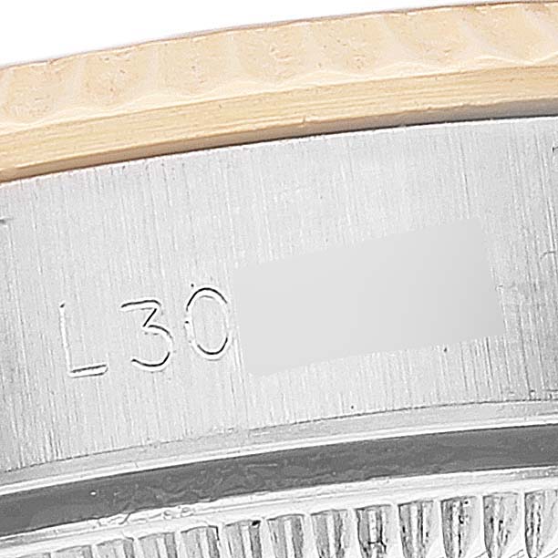 This close-up image shows the engraved inner bezel and part of the fluted bezel of the Rolex Oyster Perpetual 67193 Women's Steel and Gold (two tone) Champagne Dial 67193 Women's Steel and Gold (two tone) Champagne Dial watch.