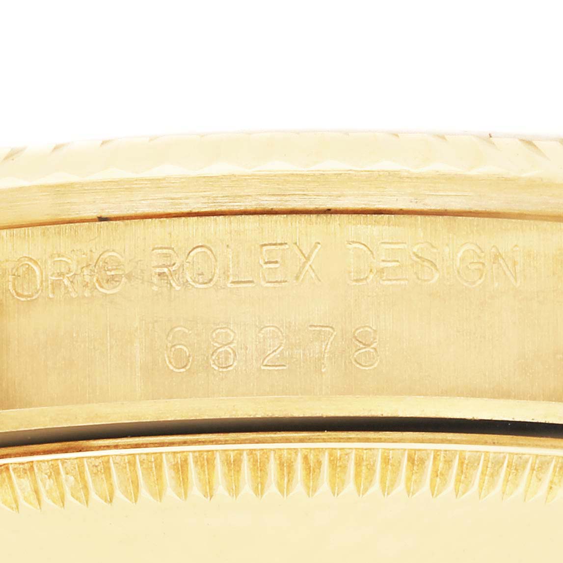 The image shows a close-up of the side of the Rolex President 68278 Women's Yellow Gold Silver Dial 68278 Women's Yellow Gold Silver Dial model, highlighting the engravings on its bezel.
