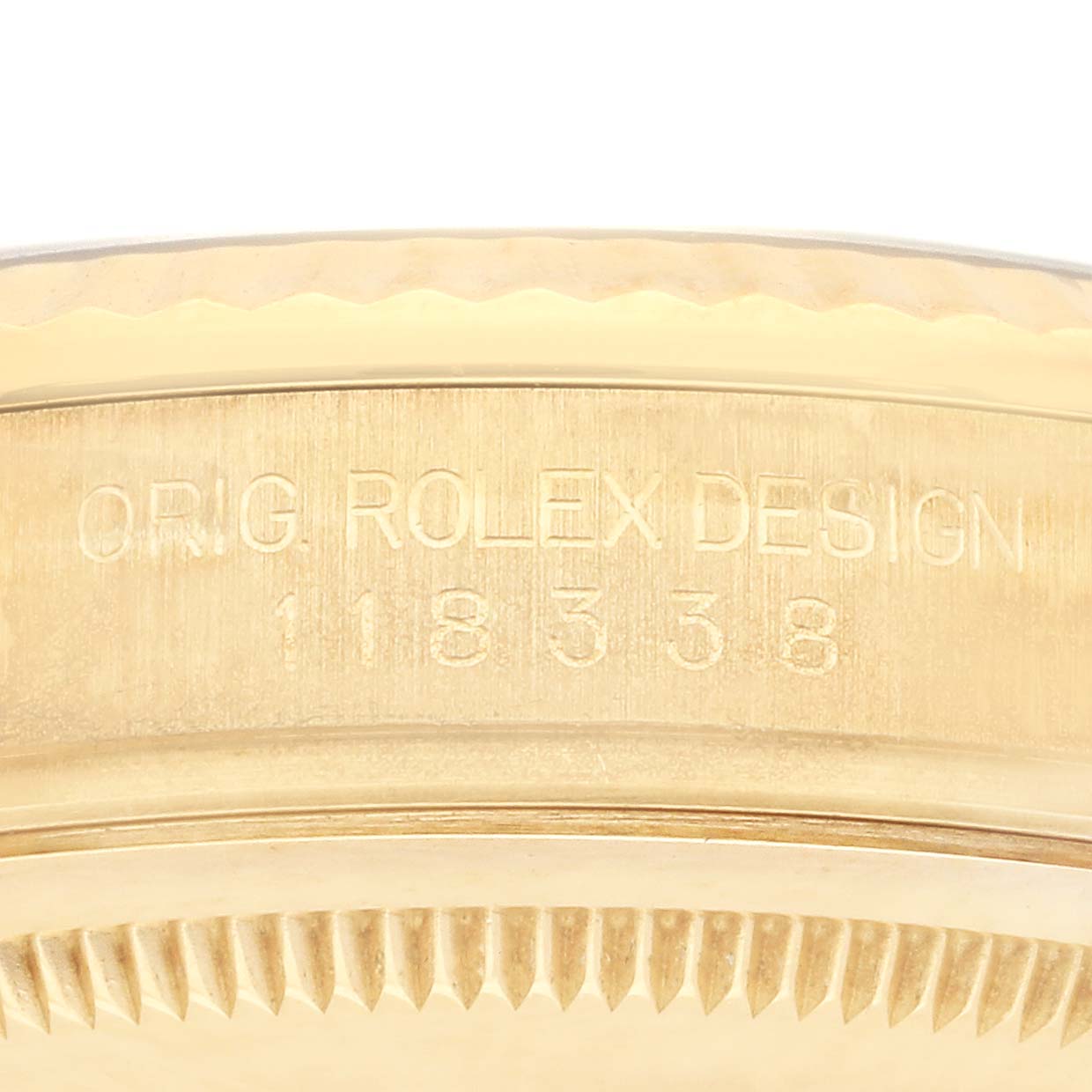 The image shows the side engraving and bezel of the Rolex President 118338 Men's Yellow Gold Champagne Dial 118338 Men's Yellow Gold Champagne Dial model, focusing on the text and serial number.