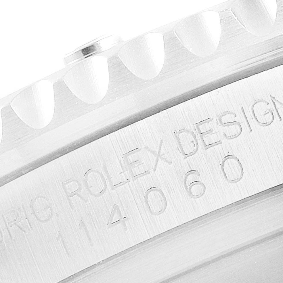 This close-up image of a Rolex Submariner 114060 Men's Stainless Steel Black Dial 114060 Men's Stainless Steel Black Dial watch shows the edge of the bezel and part of the engraved case.