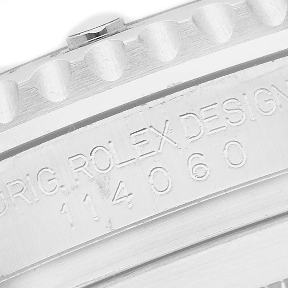 The image shows a close-up of the side of a Rolex Submariner 114060 Men's Stainless Steel Black Dial watch, highlighting the engraved serial number and part of the bezel.