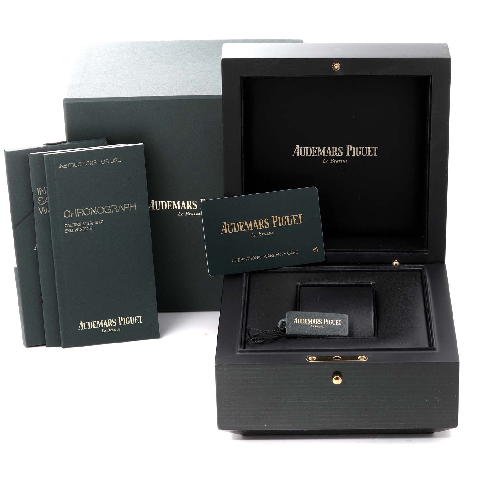 The image shows the packaging for a Royal Oak Offshore by Audemars Piguet, including the box, manuals, and warranty card.