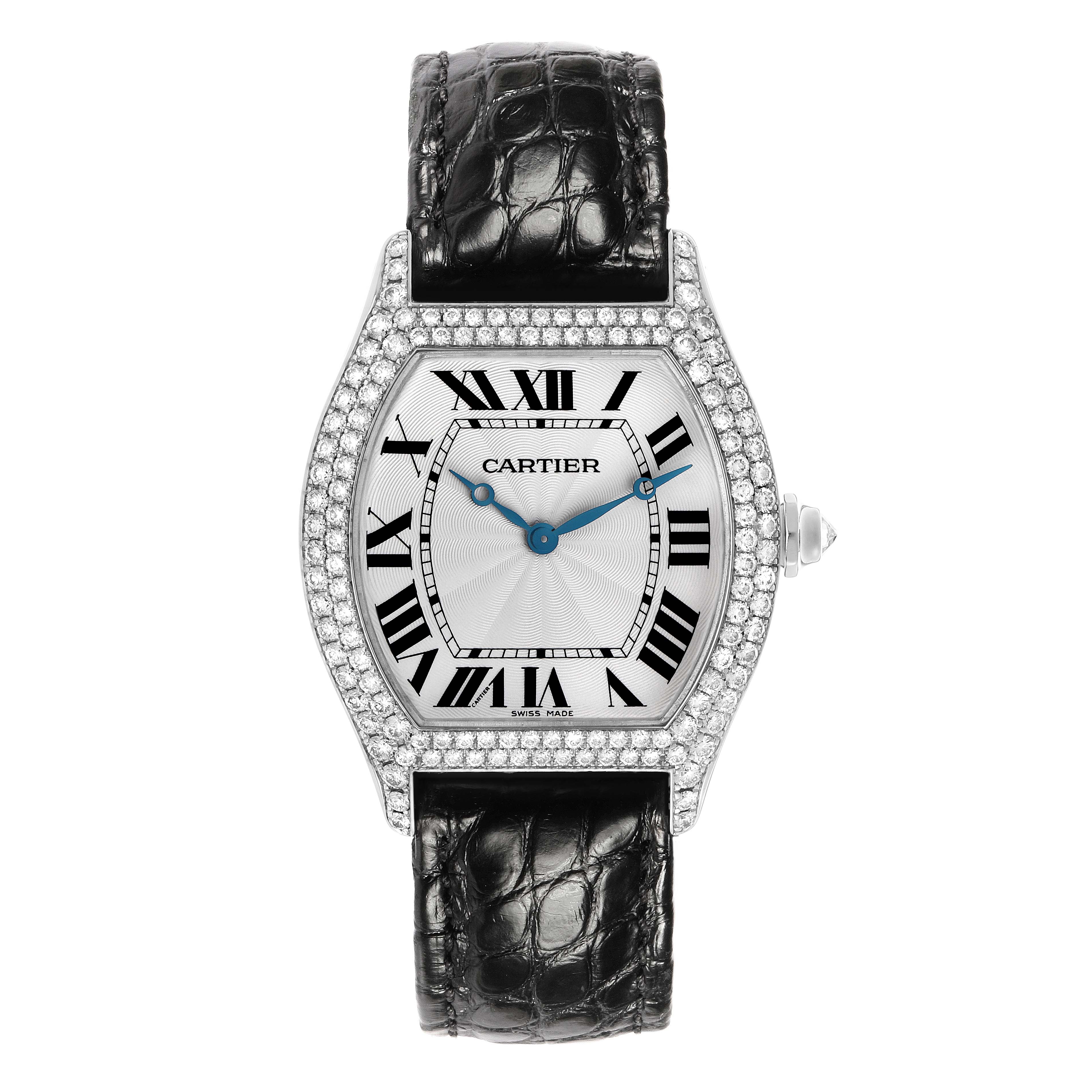 The Cartier Tortue WA504351 Men's White Gold Silver Dial watch is shown from a front view, displaying its diamond-set case, Roman numeral dial, blue hands, and black strap.