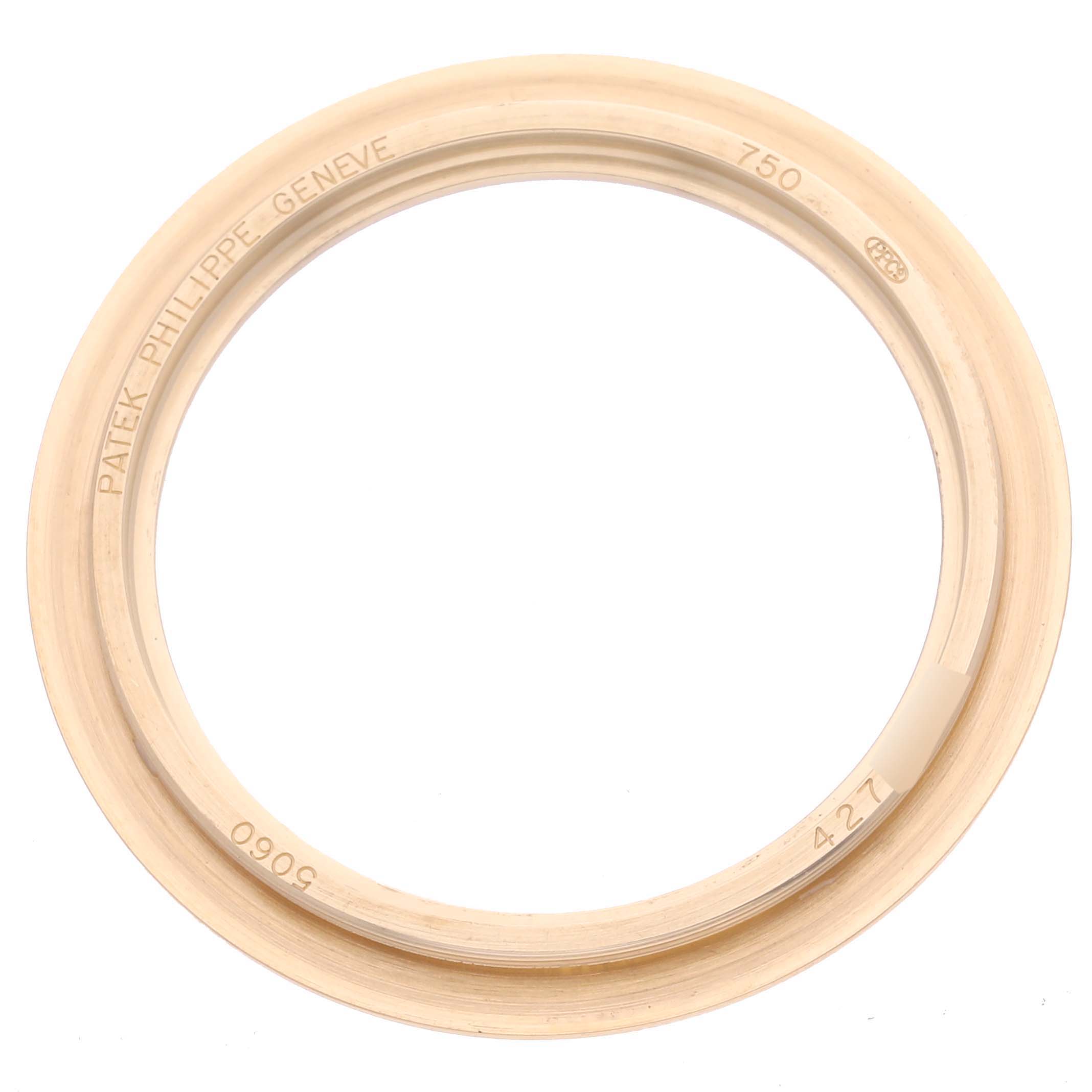 The image shows the bezel of a Patek Philippe Aquanaut 5060 Men's Yellow Gold Silver Dial 5060 Men's Yellow Gold Silver Dial watch from a top-down angle, focusing on engravings and details.