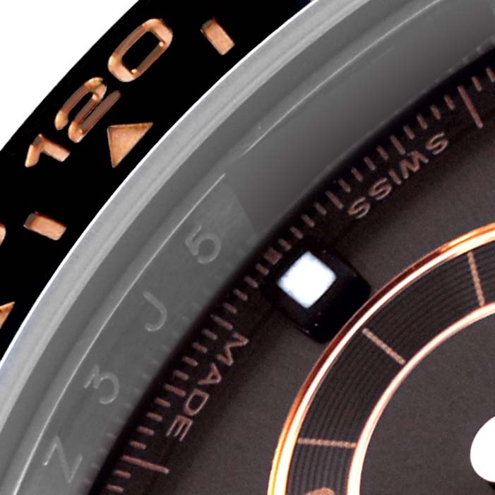 The image shows a close-up angle of the Rolex Daytona 116515LN Men's Rose Gold Brown Dial 116515LN Men's Rose Gold Brown Dial's bezel and partial face, highlighting numbers and markings.