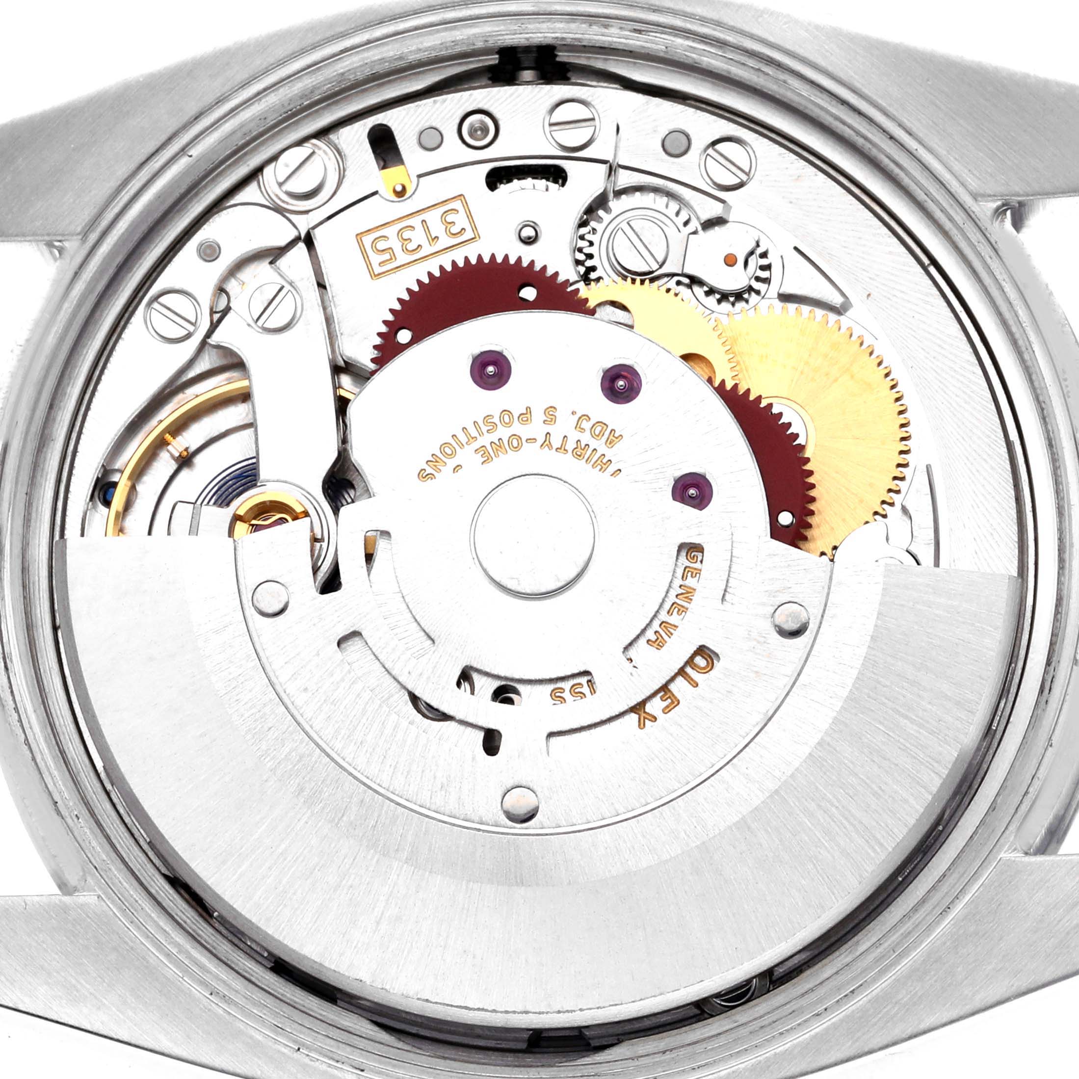 The image shows the movement of a Rolex Date 115200 Men's Stainless Steel Black Dial 115200 Men's Stainless Steel Black Dial model viewed from the back, highlighting gears and mechanical components.