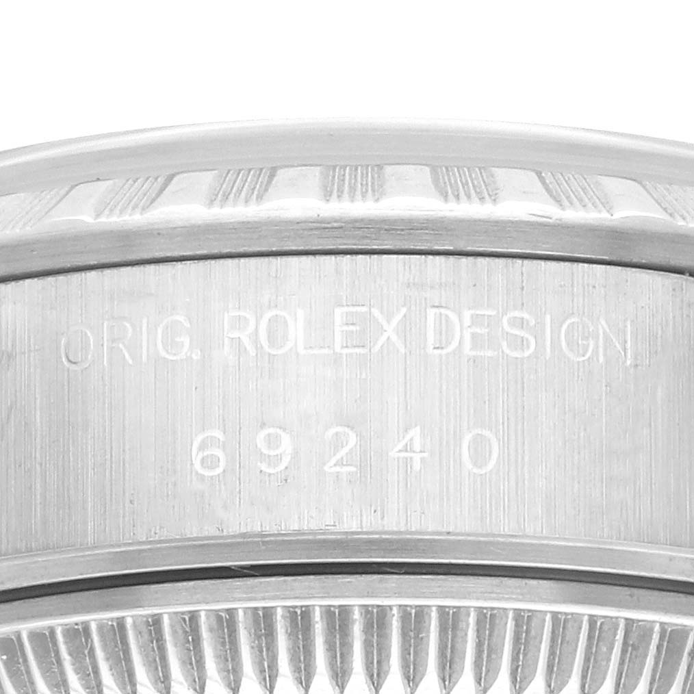 The image shows the side of a Rolex Date 69240 Women's Stainless Steel Blue Dial 69240 Women's Stainless Steel Blue Dial model, focusing on the engraved bezel and case details.